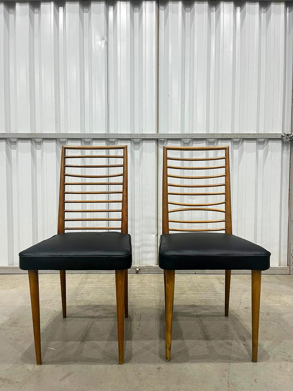 Available today, with domestic shipping in the NYC metro area included, this Brazilian Pair of Chairs in Hardwood & Leather by Joaquim Tenreiro, c. 1950s, is nothing less than gorgeous! 

Crafted from hardwood, these two chairs boast black leather