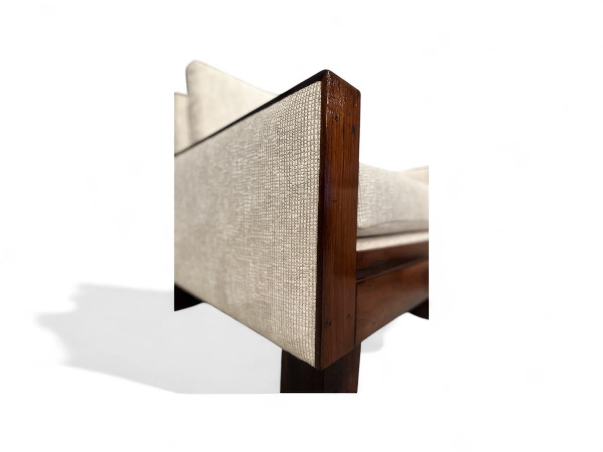 Estos sillones modernos brasileños de Celina, que datan de la década de 1960, están fabricados en palisandro brasileño y presentan una forma rectangular elegante con amplios reposabrazos. La base tiene cuatro robustas patas rectangulares.