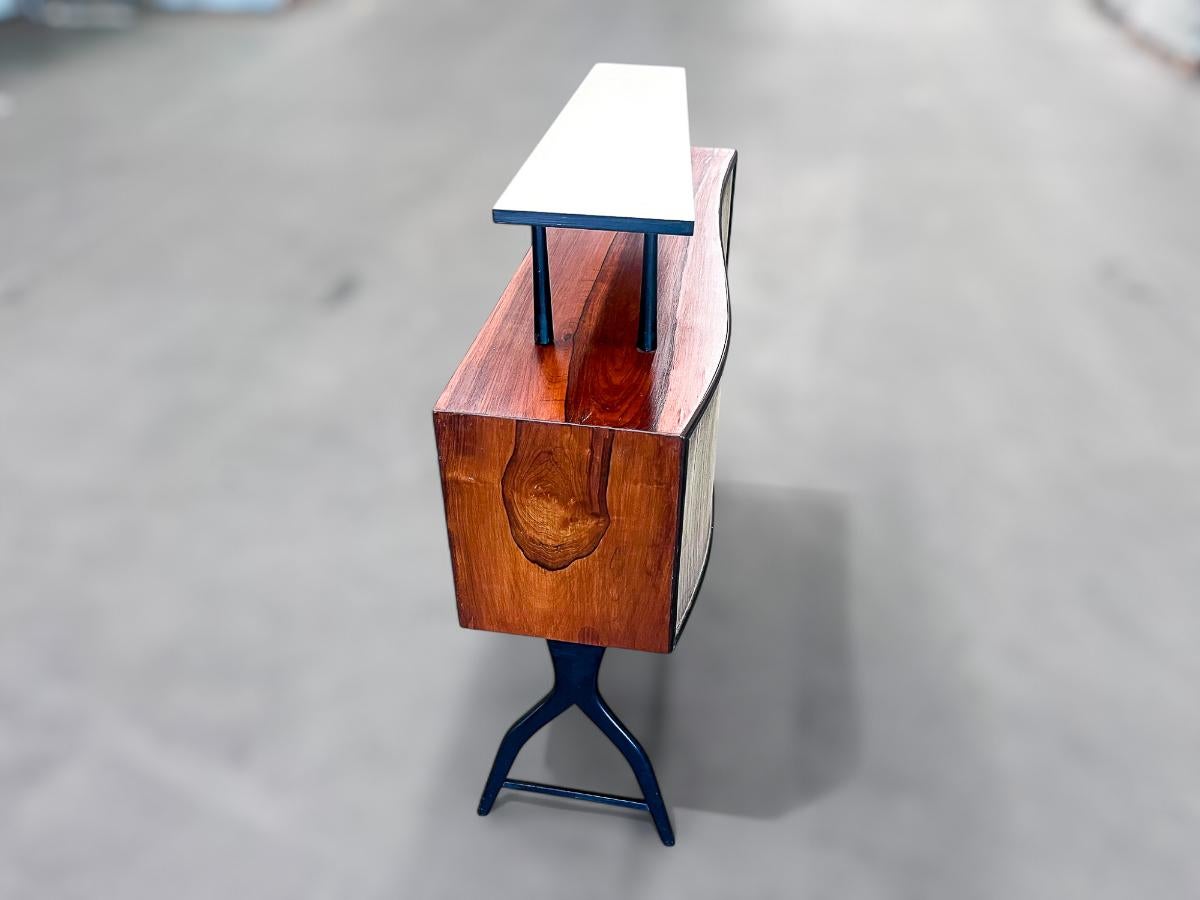 Available today, this Brazilian Mid-century Modern Bar with Curved Shape in Two Woods, made in the 50's is nothing less than gorgeous!

This exquisite bar features sturdy hardwood legs with an ebony finish, and its surfaces and sides are beautifully