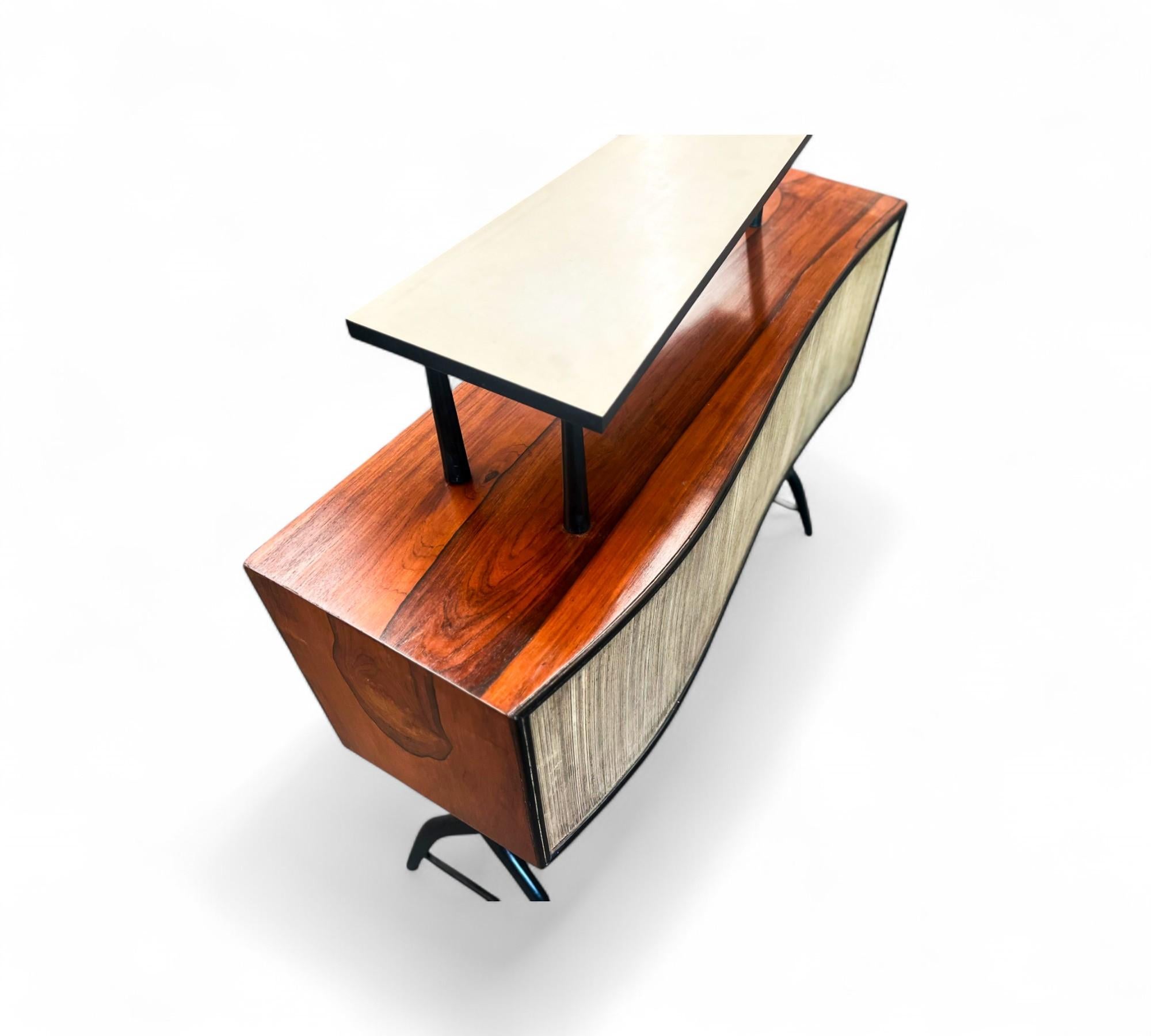 Available today, this Brazilian Mid-century Modern Bar with Curved Shape in Two Woods, made in the 50's is nothing less than gorgeous!

This exquisite bar features sturdy hardwood legs with an ebony finish, and its surfaces and sides are beautifully