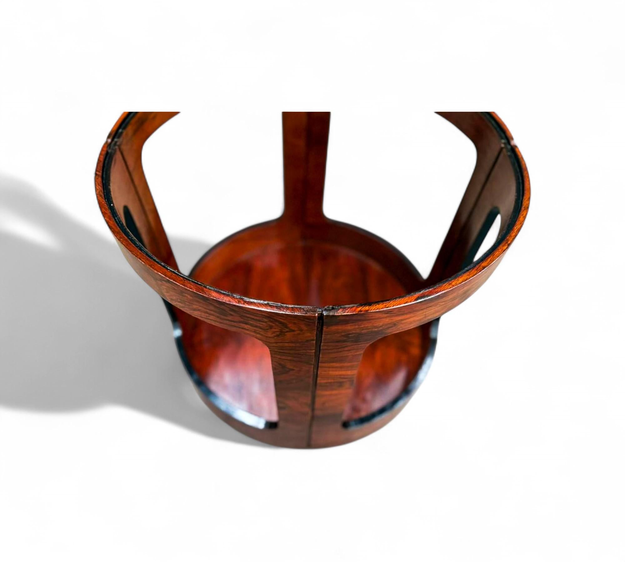 Cette table d'appoint sculpturale en bois dur, attribuée à Bertomeu et fabriquée dans les années 1950-1960. La forme cylindrique est définie par quatre panneaux ouverts et incurvés qui mettent en valeur le grain riche et la profondeur du bois dur