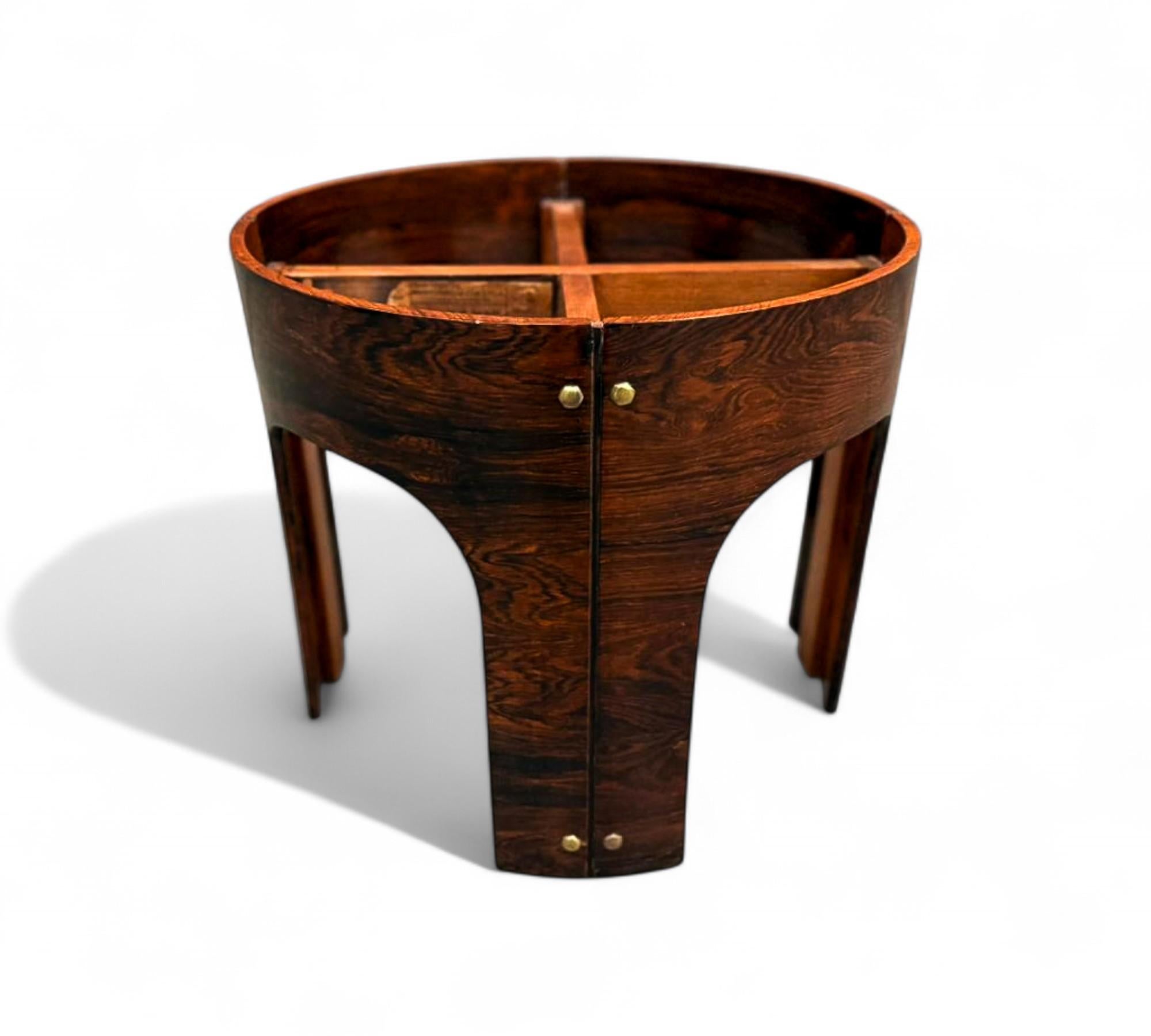 Cette table d'appoint sculpturale des années 1960, signée Eleg, met en valeur la riche élégance du bois dur brésilien, soulignée par son grain spectaculaire et ses variations de tons chauds. Les pieds arqués distinctifs de la table et sa forme