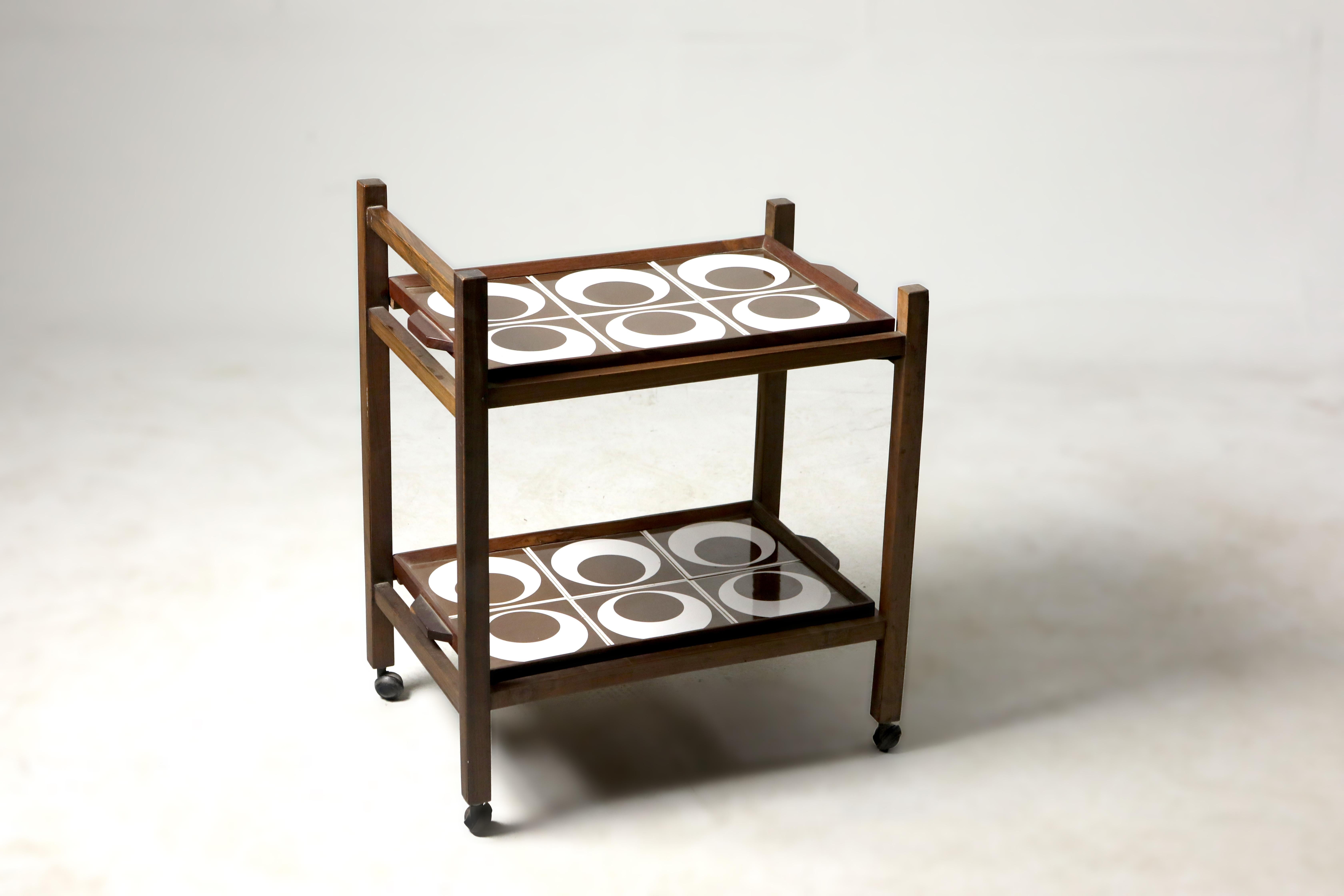Brazilian Mid-Century Modern tile and hardwood tea-cart or bar-cart, Brazil, 1960s.

Structured in solid Brazilian hardwood, this charming 1960s tea-cart features two removable trays lined with brown and white ceramic tiles and casters for