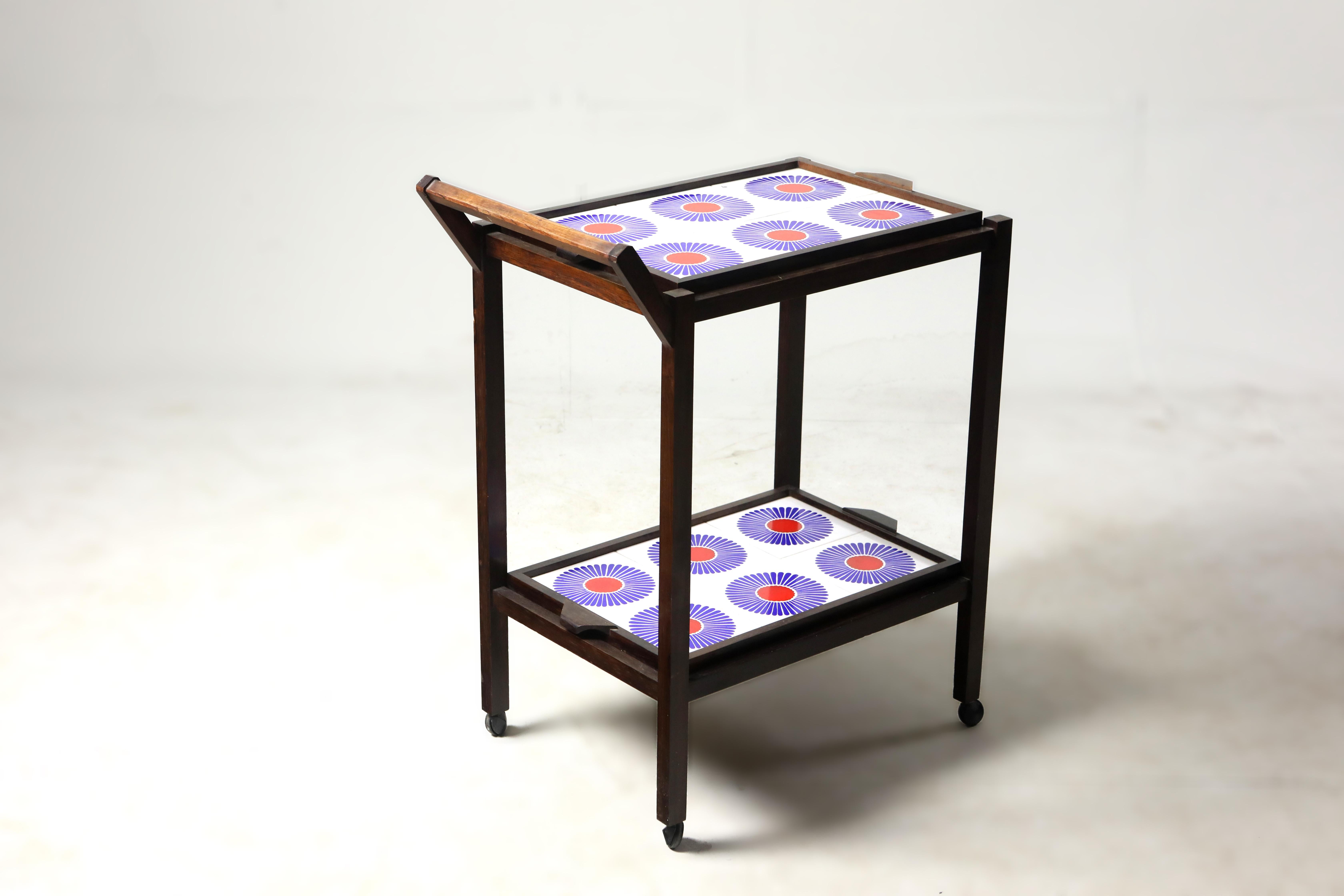 Brazilian Mid-Century Modern tile and hardwood tea-cart or bar-cart, Brazil, 1960s.

Structured in solid Brazilian hardwood, this charming 1960s tea-cart features two removable trays lined with floral motif ceramic tiles and casters for mobility.
