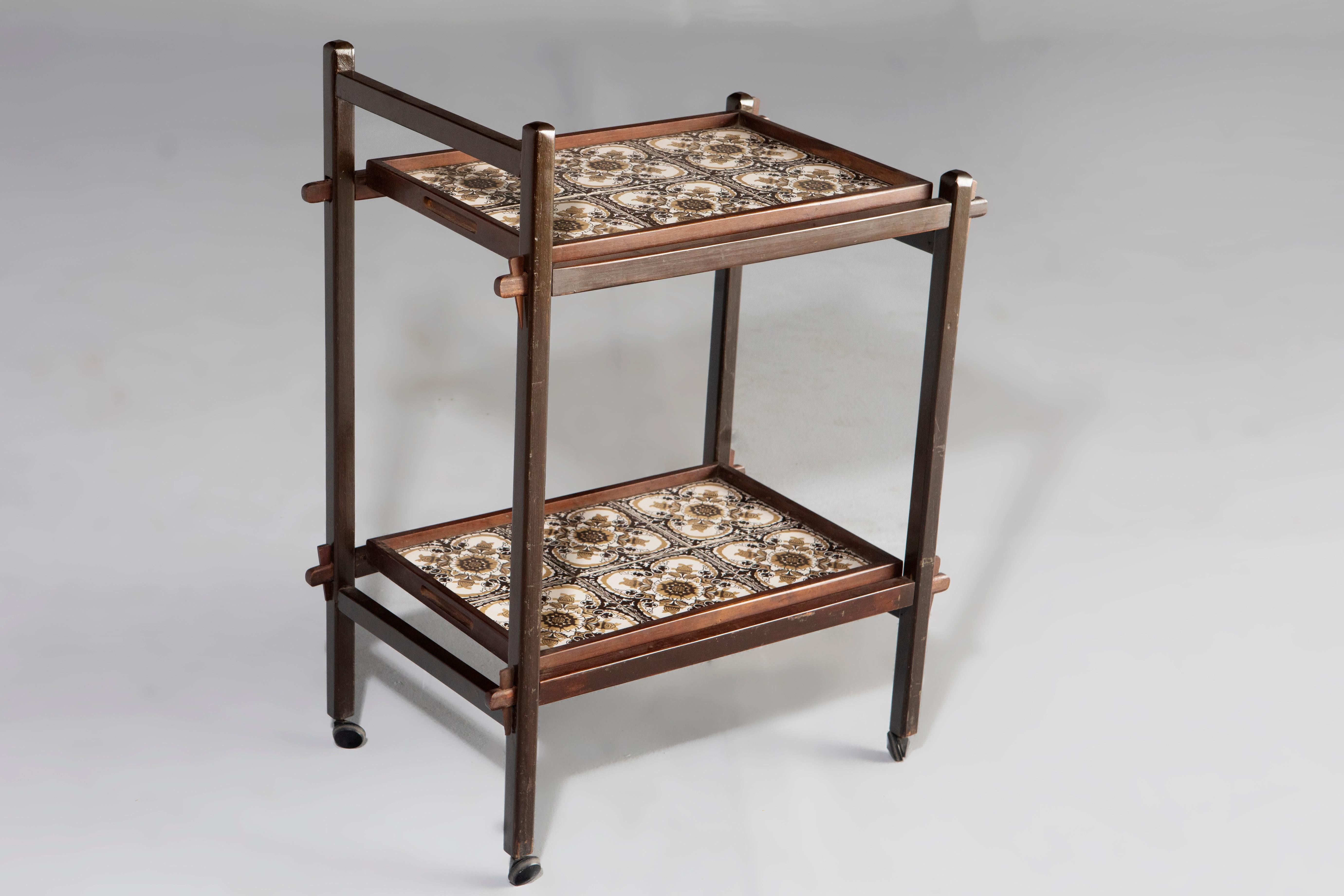 Brazilian Mid-Century Modern tile and hardwood tea-cart or bar-cart, Brazil, 1960s.

Structured in solid Brazilian hardwood, this charming 1960s tea-cart features two removable trays lined with floral motif ceramic tiles and casters for mobility.