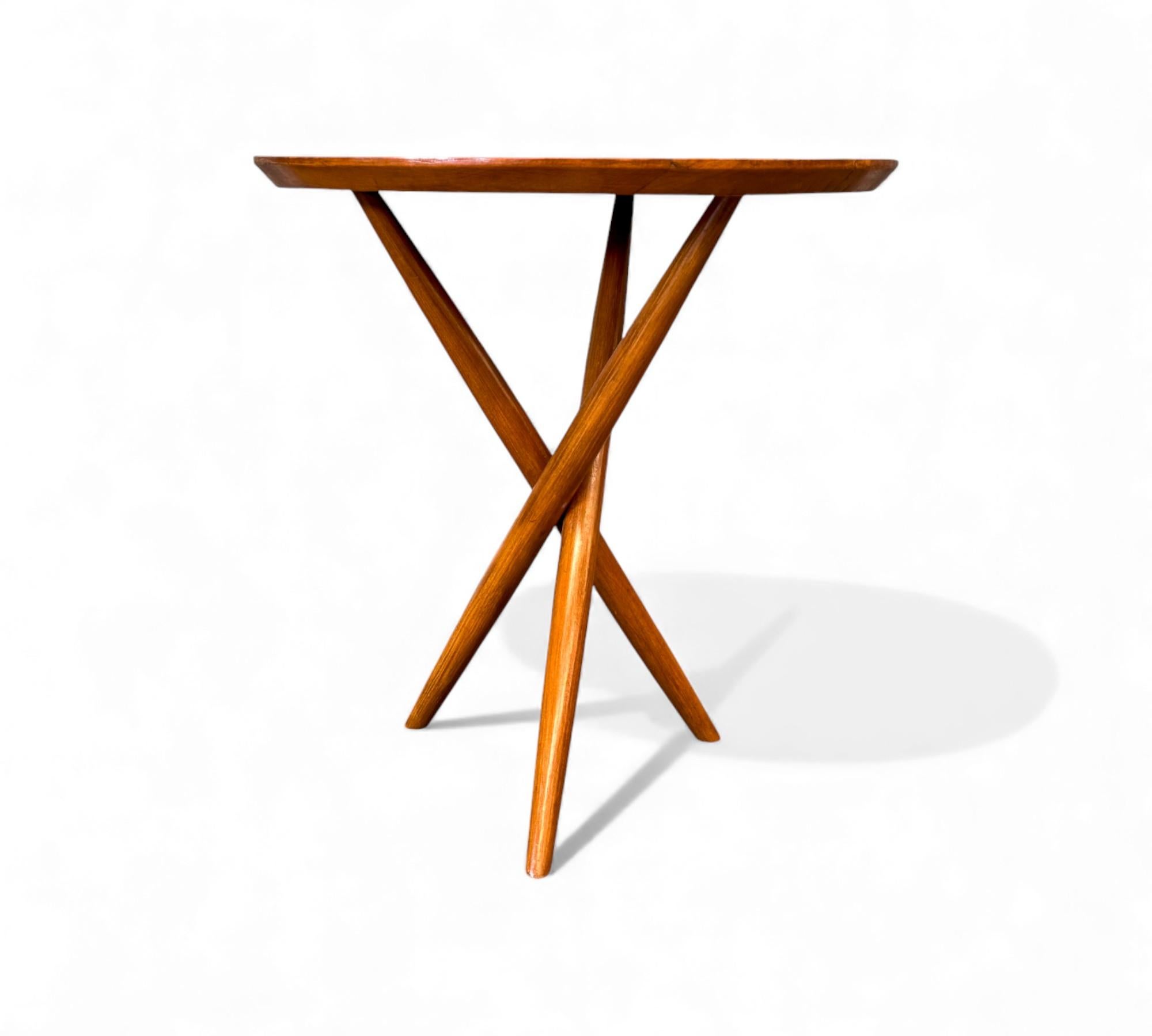 Cette étonnante table d'appoint à trois pieds, attribuée à un designer brésilien inconnu vers 1950, est dotée de pieds ronds et d'un plateau en bois dur massif - oui, le plateau est entièrement massif. Les pieds de la table sont tressés. Le bois a