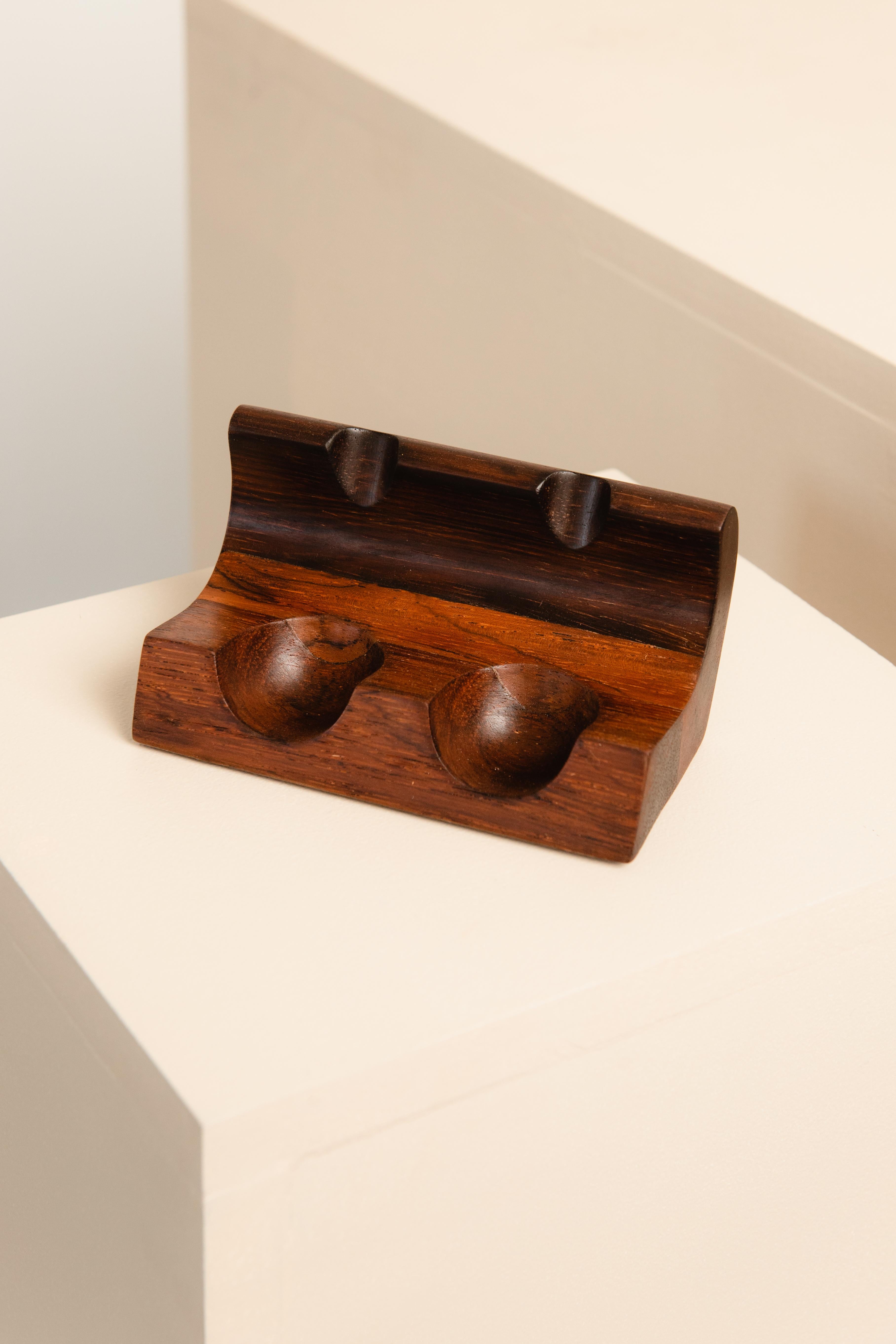 Solid rosewood pipe holder by Jean Gillon model 822 from the WoodArt catalogue.

Jean Gillon (1919-2007) was born in Romania, where he graduated in Architecture and Fine Arts. In 1956 he moved to Brazil, where he developed his work in three