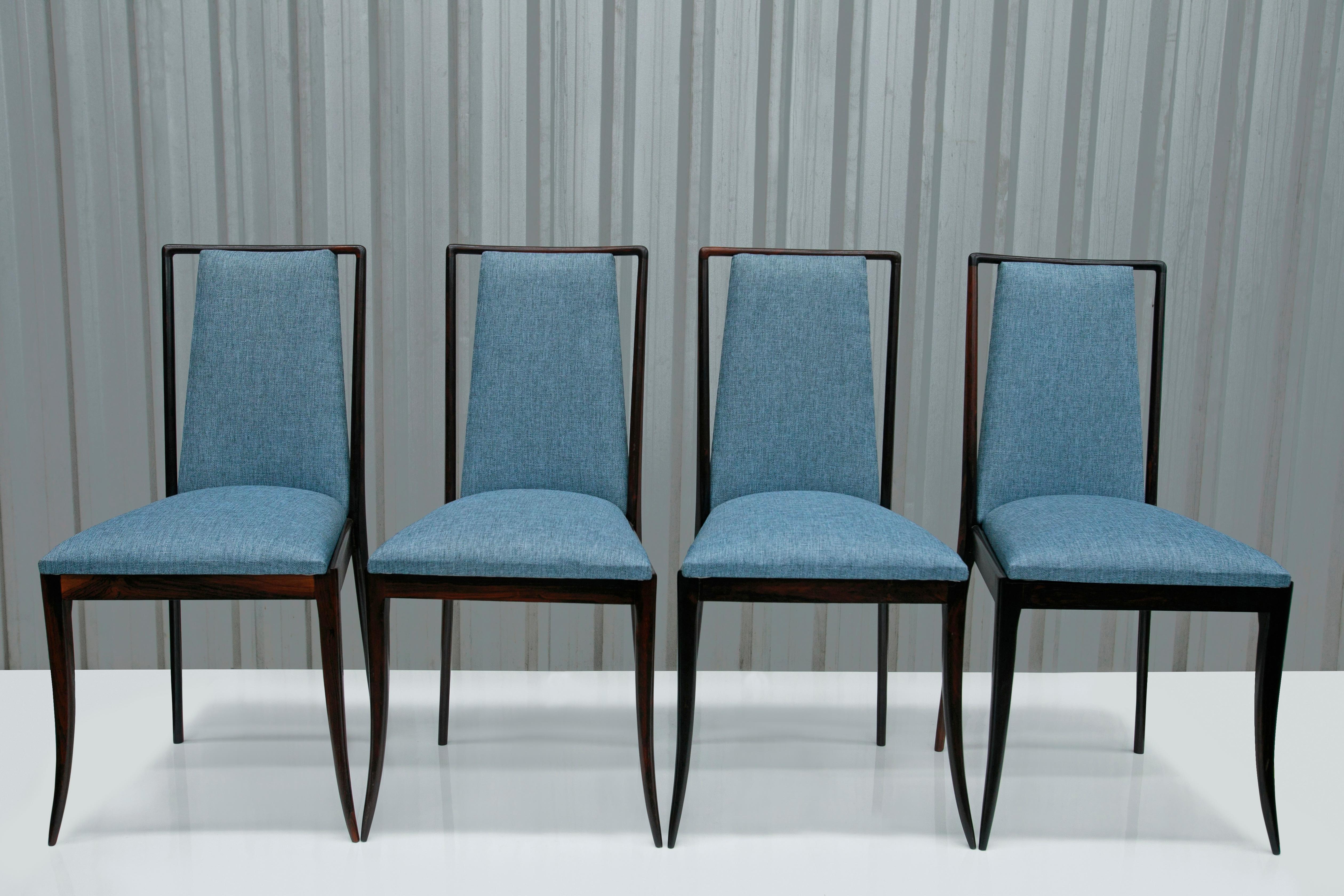 Available today, this sculptural Mid-Century Modern four chair set in hardwood & blue fabric, designed in the fifties in Brazil is nothing less than spectacular!

Each chair features a Brazilian rosewood (known as Jacaranda) structure with a tall