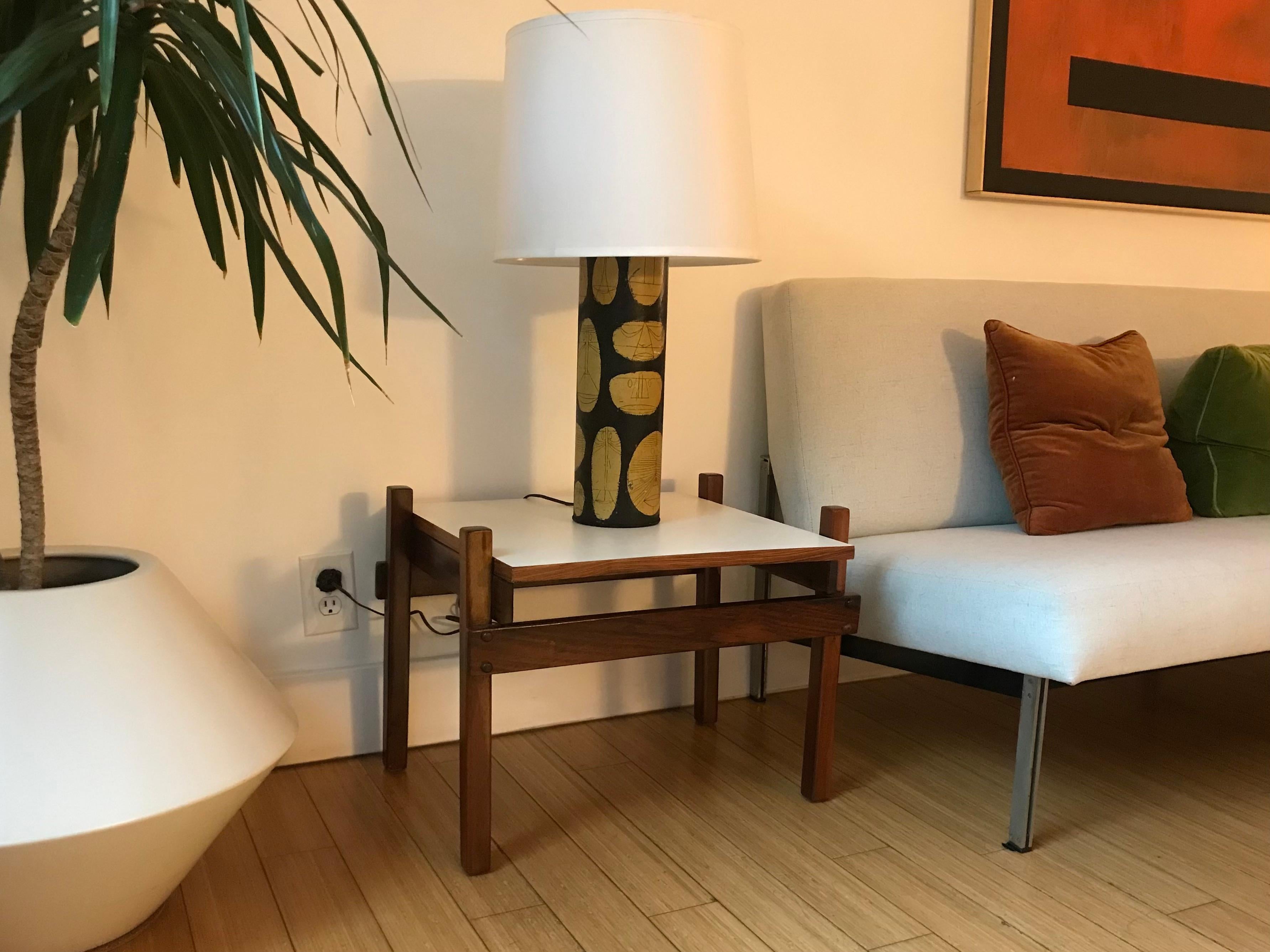 Rare and handsome tables.
Architectural design.
Solid Brazilian rosewood with a beautiful grain and hue.
White laminate tops with rosewood trim.
Original vintage condition.
Two barely visible veneer nicks on the table edge and one scratch on