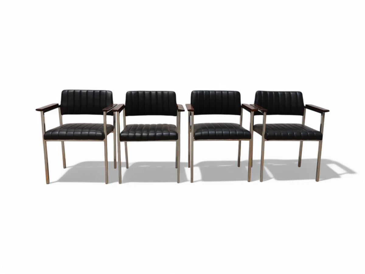 Disponibili oggi, queste poltrone moderne brasiliane in acciaio, pelle e legno Unknown, anni '60, Brasile, sono bellissime. 

La struttura di queste sedie è in acciaio e la seduta e lo schienale sono in pelle nera. Inoltre, i braccioli sono