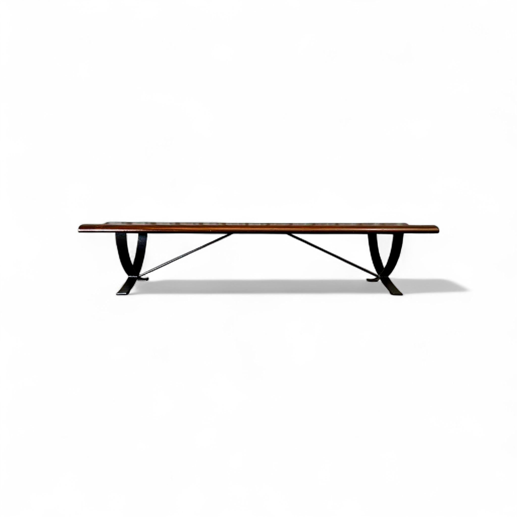 Ce banc sculptural des années 1960, créé par le Liceu de Artes e Ofícios, présente une assise en bois de rose profilée associée à une base en fer incurvée, mettant en valeur le savoir-faire raffiné du design moderne brésilien. Le banc présente une