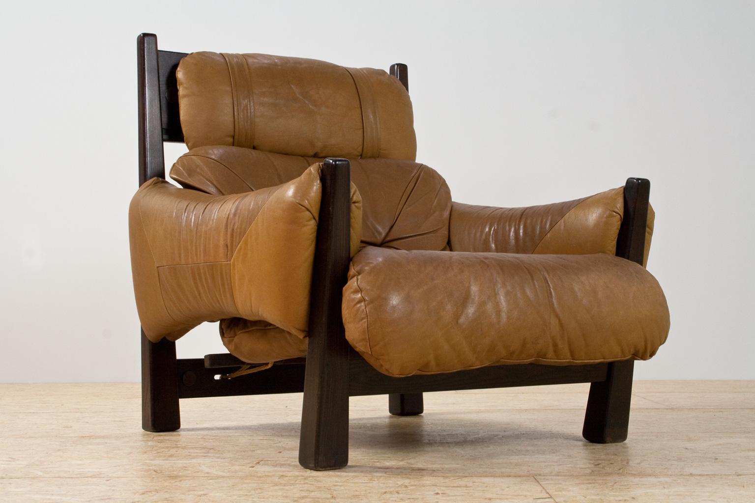The dark asymmetrical ash wooden legs, the upholstered camel colored leather seating and armrests and the rope construction of the back seating, all refer to the iconic Brazilian modern and almost Brutalist designs of Percival Lafer. At present we