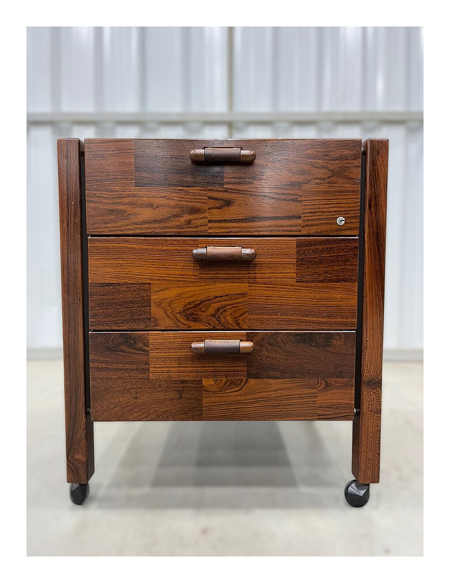 Immediately available with complementary shipping n NYC area this Brazilian modern filing cabinet in Rosewood and leather is a true beauty!

This filing cabinet was designed by Jorge Zalszupin and has three drawers with a leather handles, four