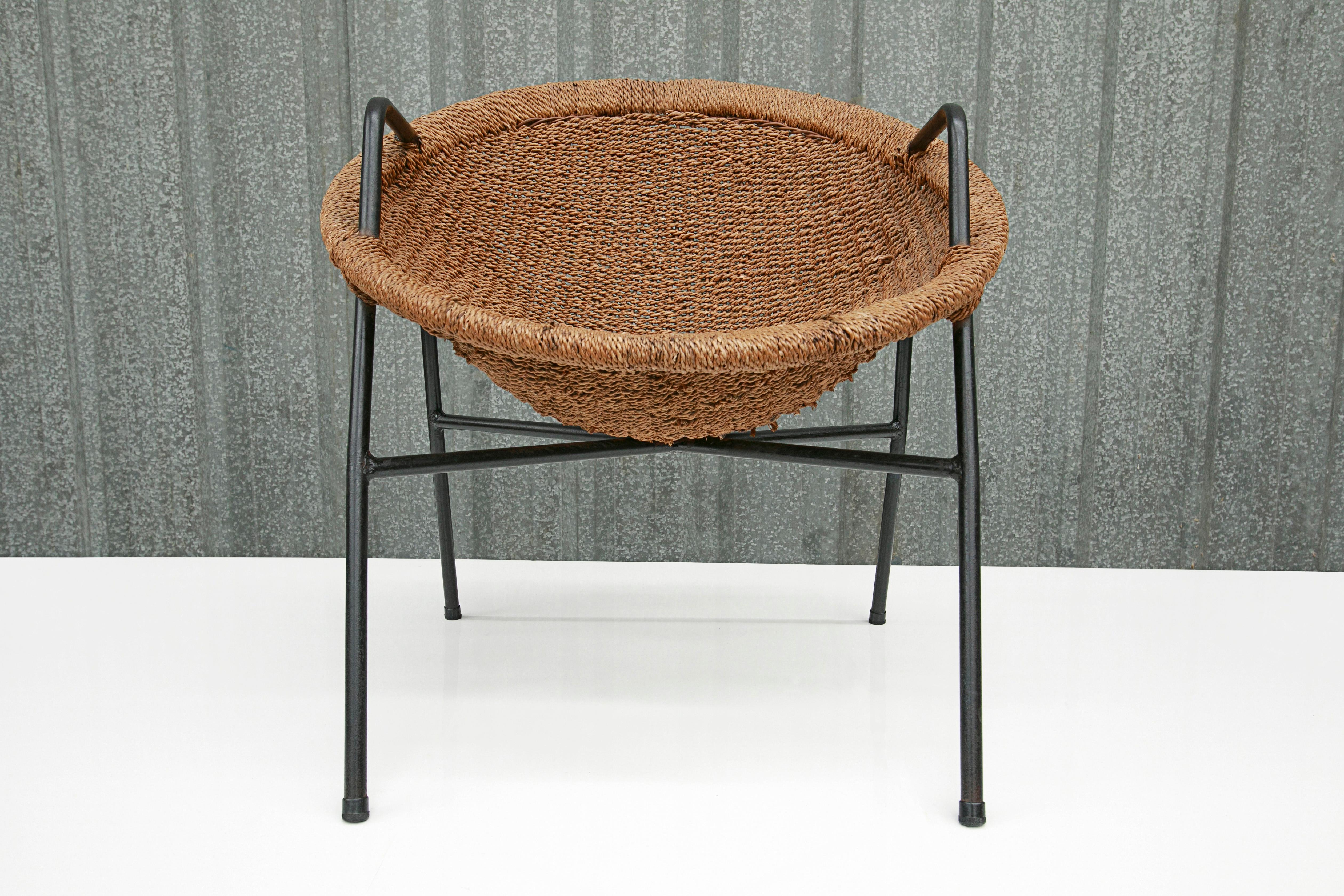 Cette chaise moderne brésilienne a été conçue par Carlo Hauner & Martin Eisler et est absolument magnifique. La structure est en fer et le siège est en rotin. Les pieds de la chaise sont très fins et l'assise est arrondie et inclinée vers l'arrière,