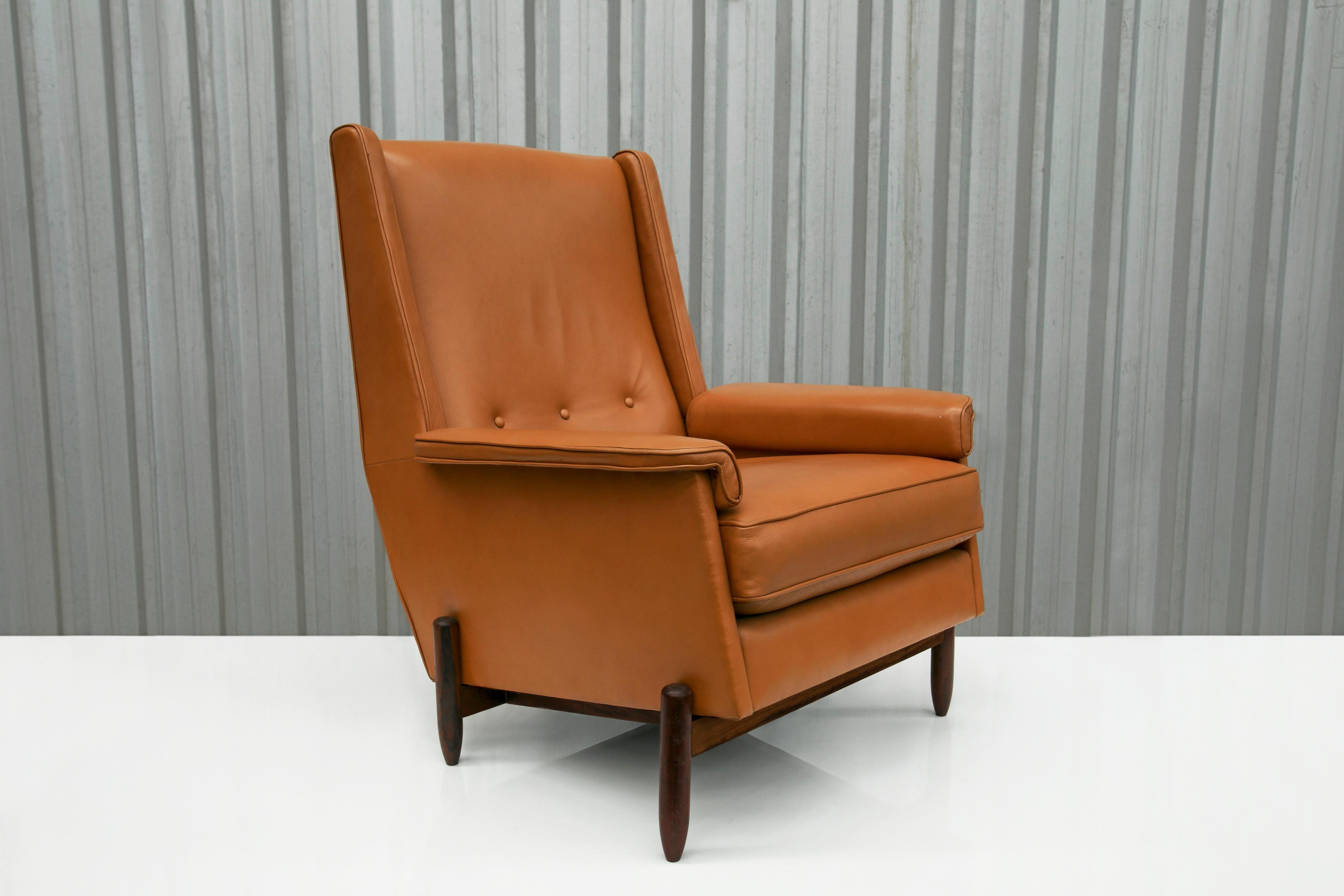 Available today, this spectacular Brazilian modern club chair, designed by Jorge Jabour in the sixties, is beautiful! The legs and body of this chair are made with hardwood and have upholstered seats in orange leather. The wood on this piece has