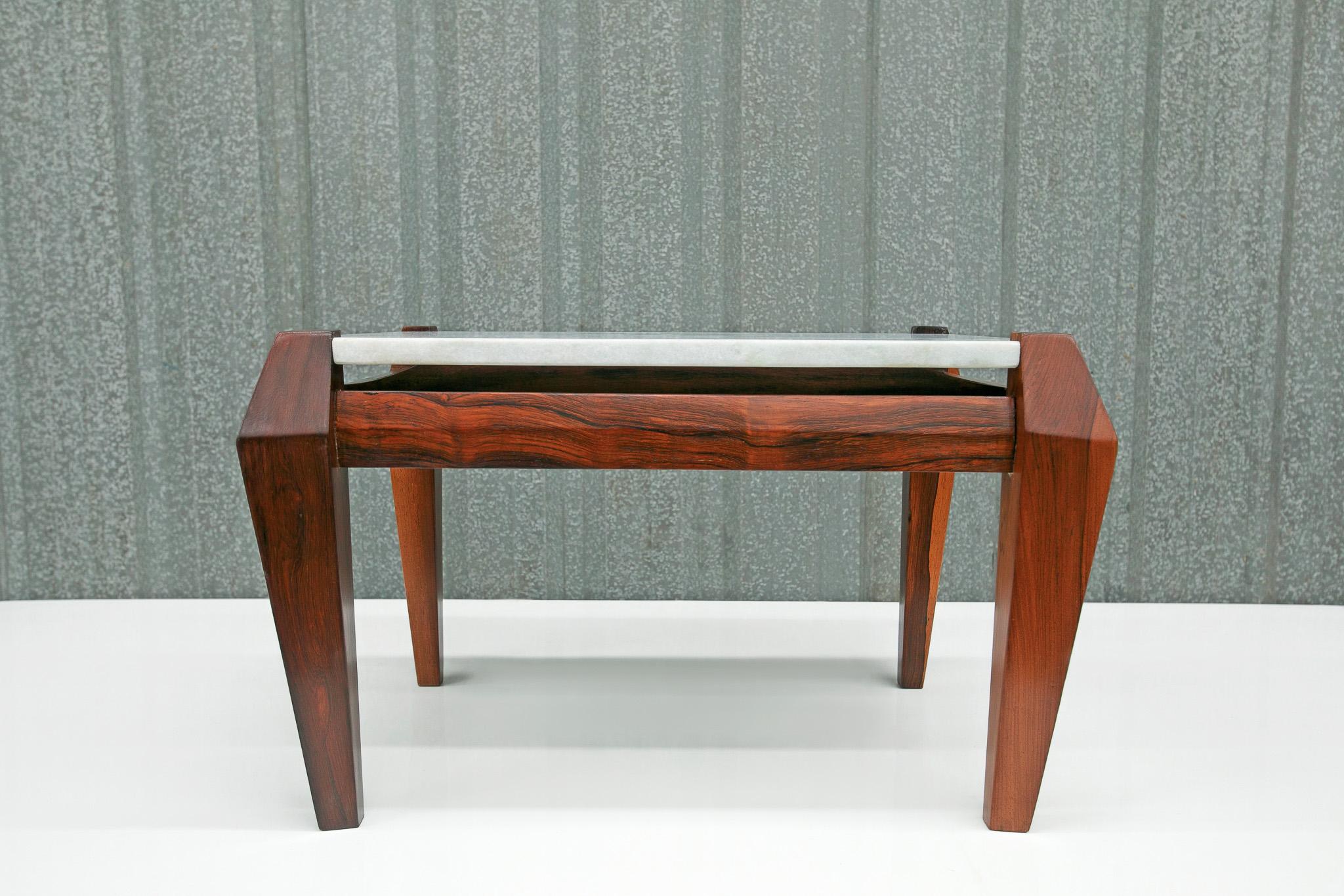 Disponible aujourd'hui, cette table basse moderne du milieu du siècle, en palissandre massif et marbre, conçue par Jean Gillon dans les années 60, n'est rien de moins que spectaculaire !

Ce qui rend cette table basse si particulière, c'est le