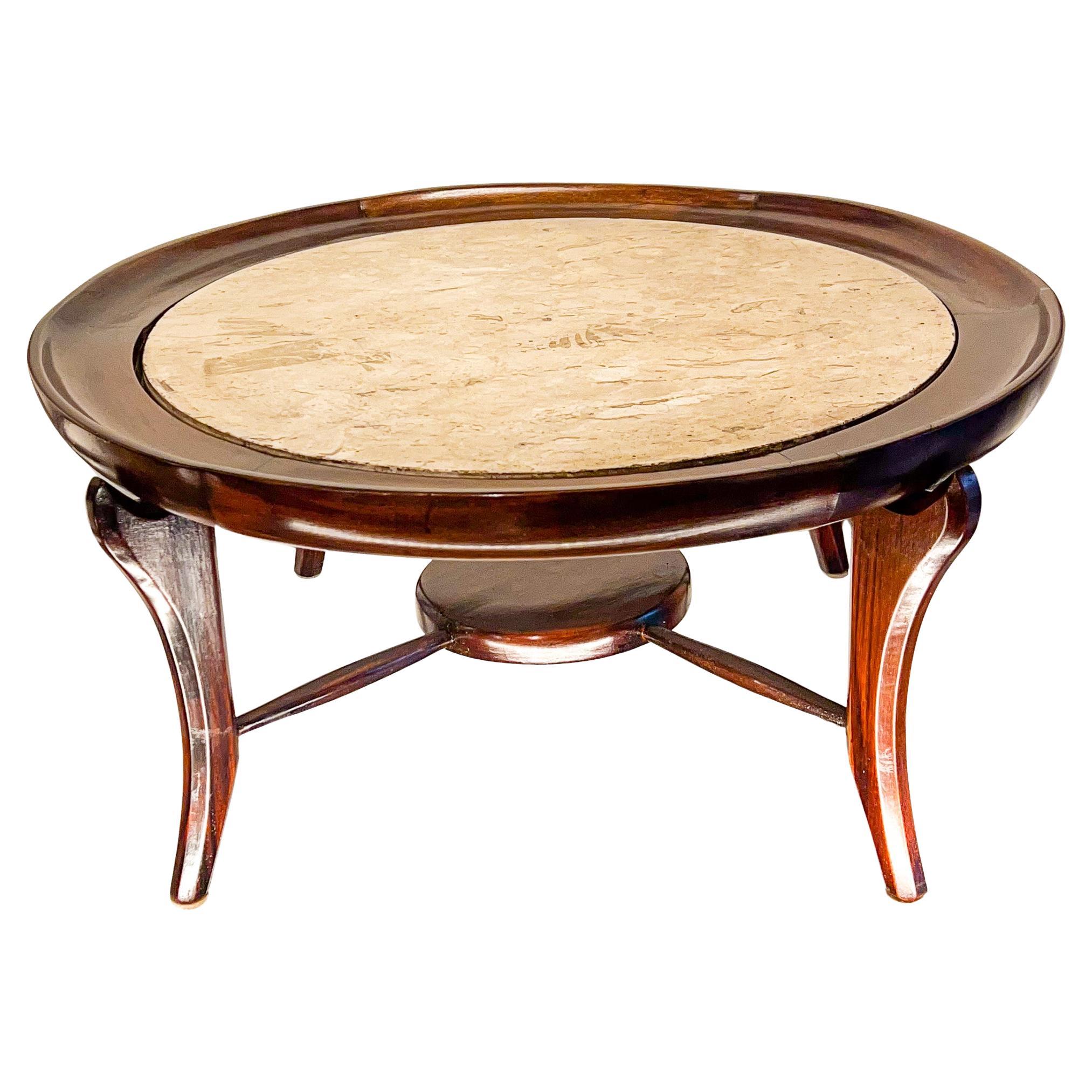 Disponible hoy, la icónica mesa de centro Maracanã de Giuseppe Scapinelli está hecha de palisandro brasileño, además de jacarandá y travertino. La parte superior tiene una base circular de madera que sostiene el travertino, dando un aspecto