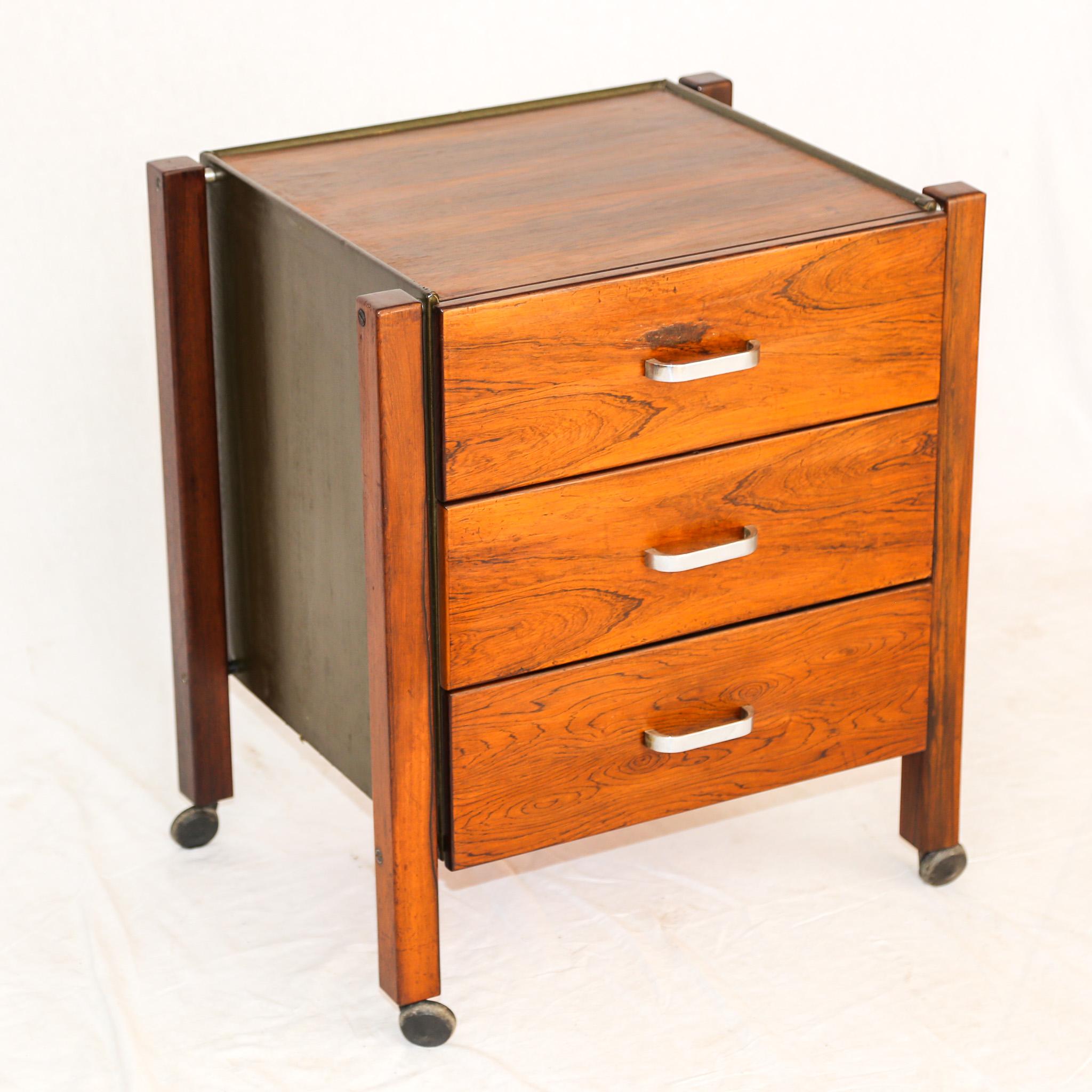 Available today, this Brazilian modern filing cabinet in Brazilian rosewood and leather is a true beauty. This filing cabinet was designed by Jorge Zalszupin and has three drawers with a metal handle, four wheels, and leather on the outside frame.