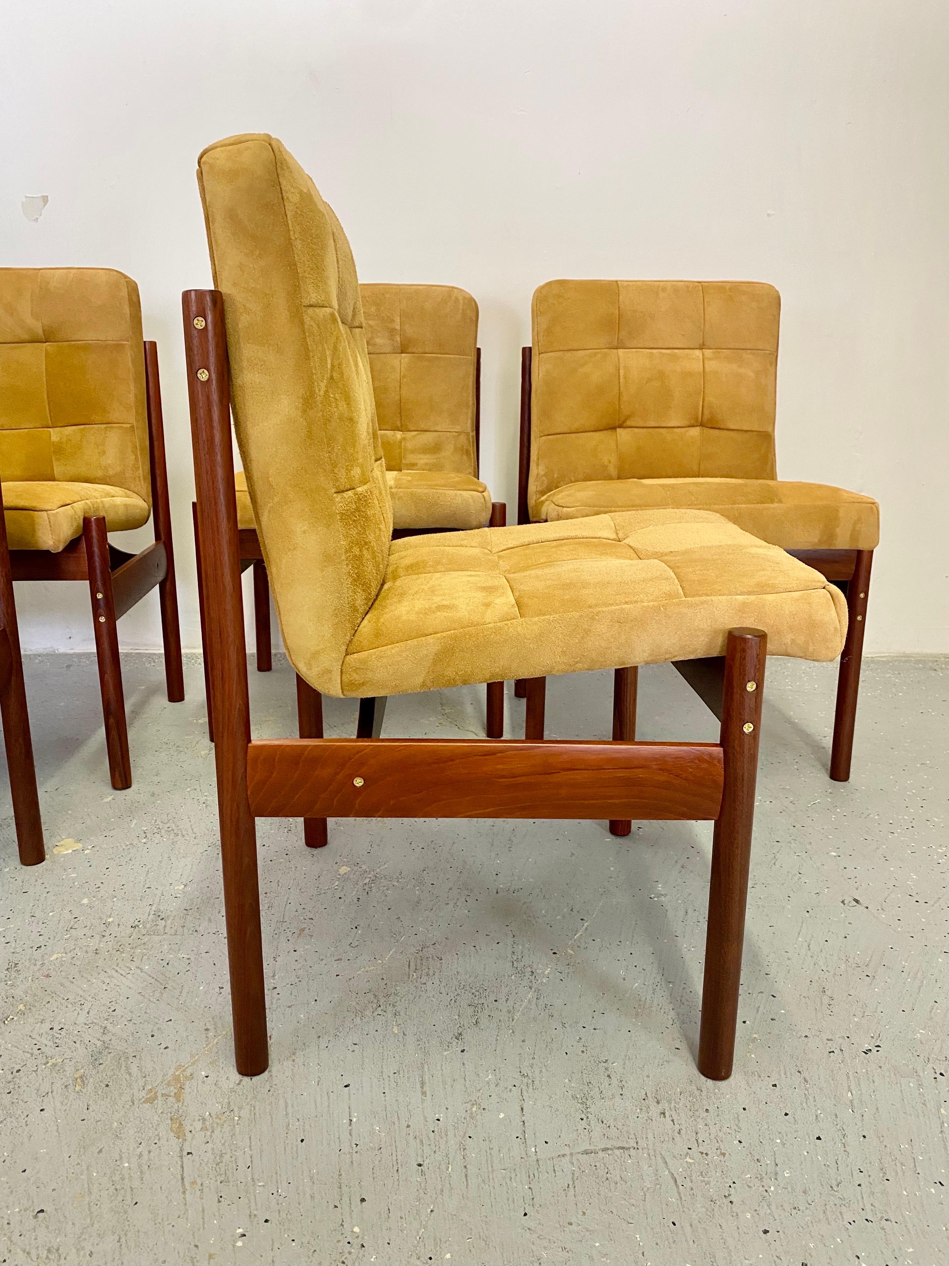 An incredible set of Brazilian dining chairs. The jacaranda rosewood frames have been fully restored with all new hardware installed. These feature rich grained rosewood with exposed brass hardware and newly upholstered suede seats. A striking set
