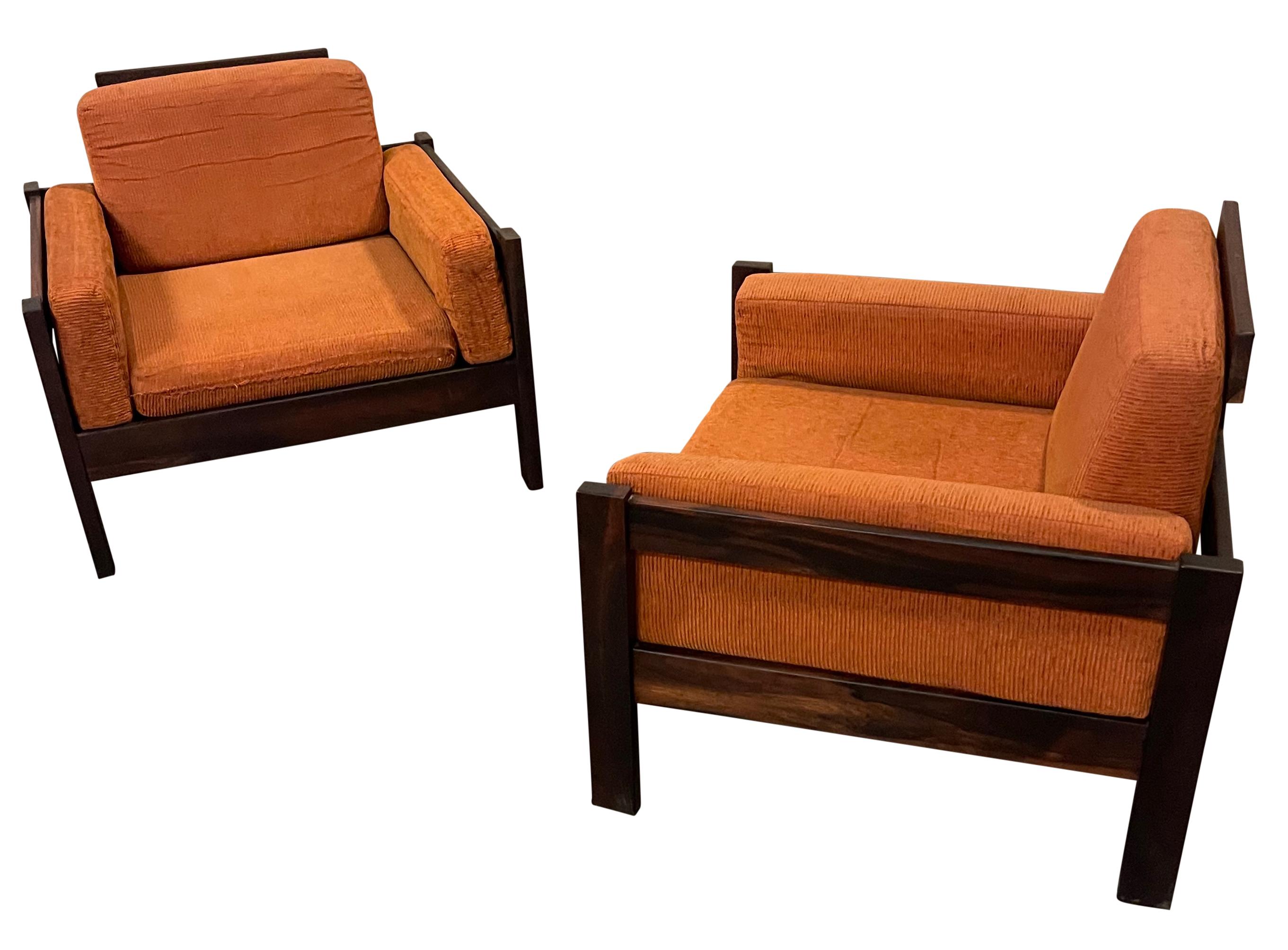 Exceptionnelle paire de chaises longues modernistes brésiliennes de Móveis Cimo, années 1960. Sculpturalement fabriqués en palissandre brésilien massif, ces fauteuils club sont des icônes rares et précieuses du design. 
L'état et le rembourrage sont