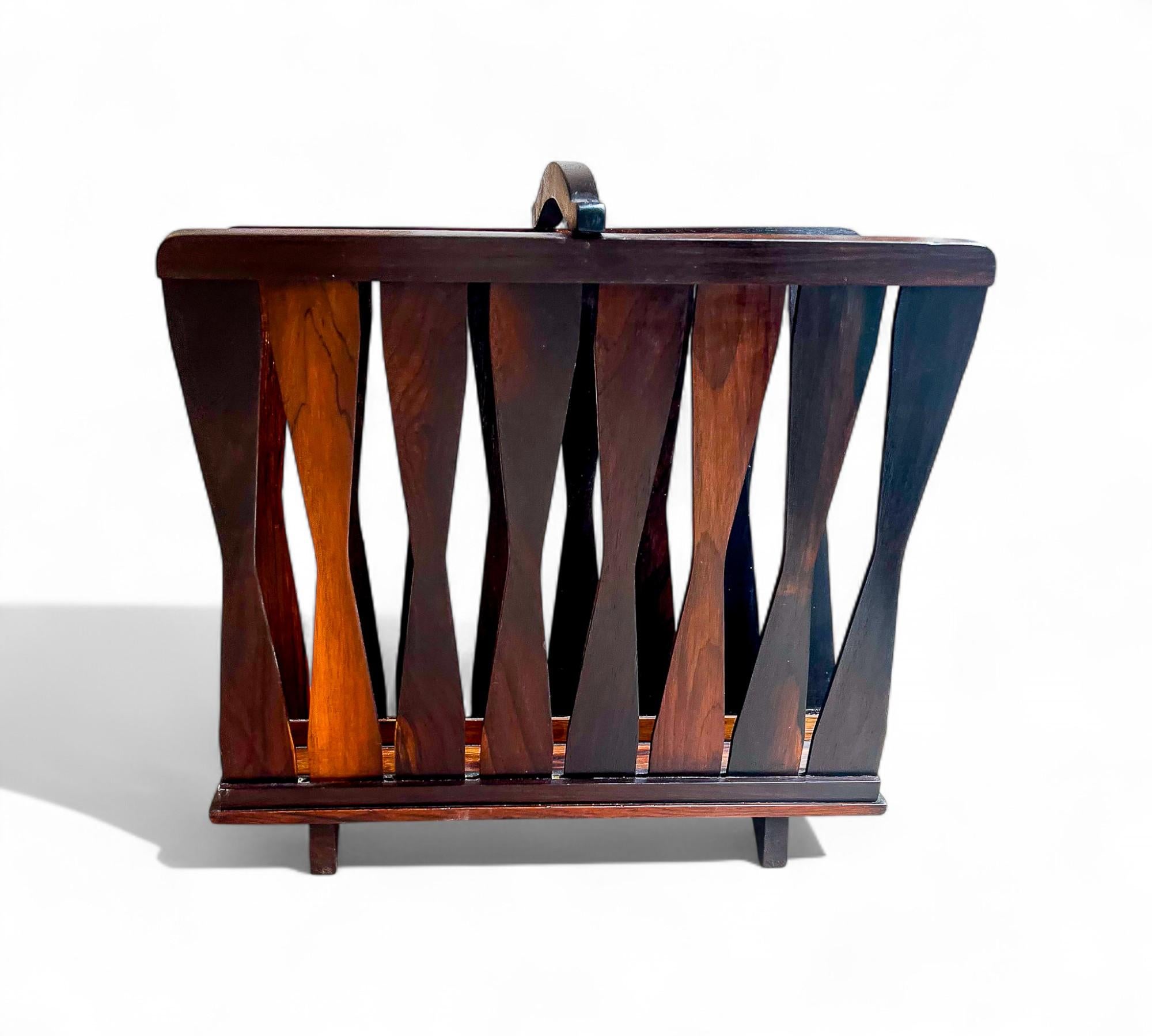 Available today, this Brazilian Modern magazine rack in Jacaranda hardwood is stunning!

This magazine rack is made with Brazilian Rosewood which is also known as Jacaranda hardwood. It is a dark brown color and would be a perfect fit for any office