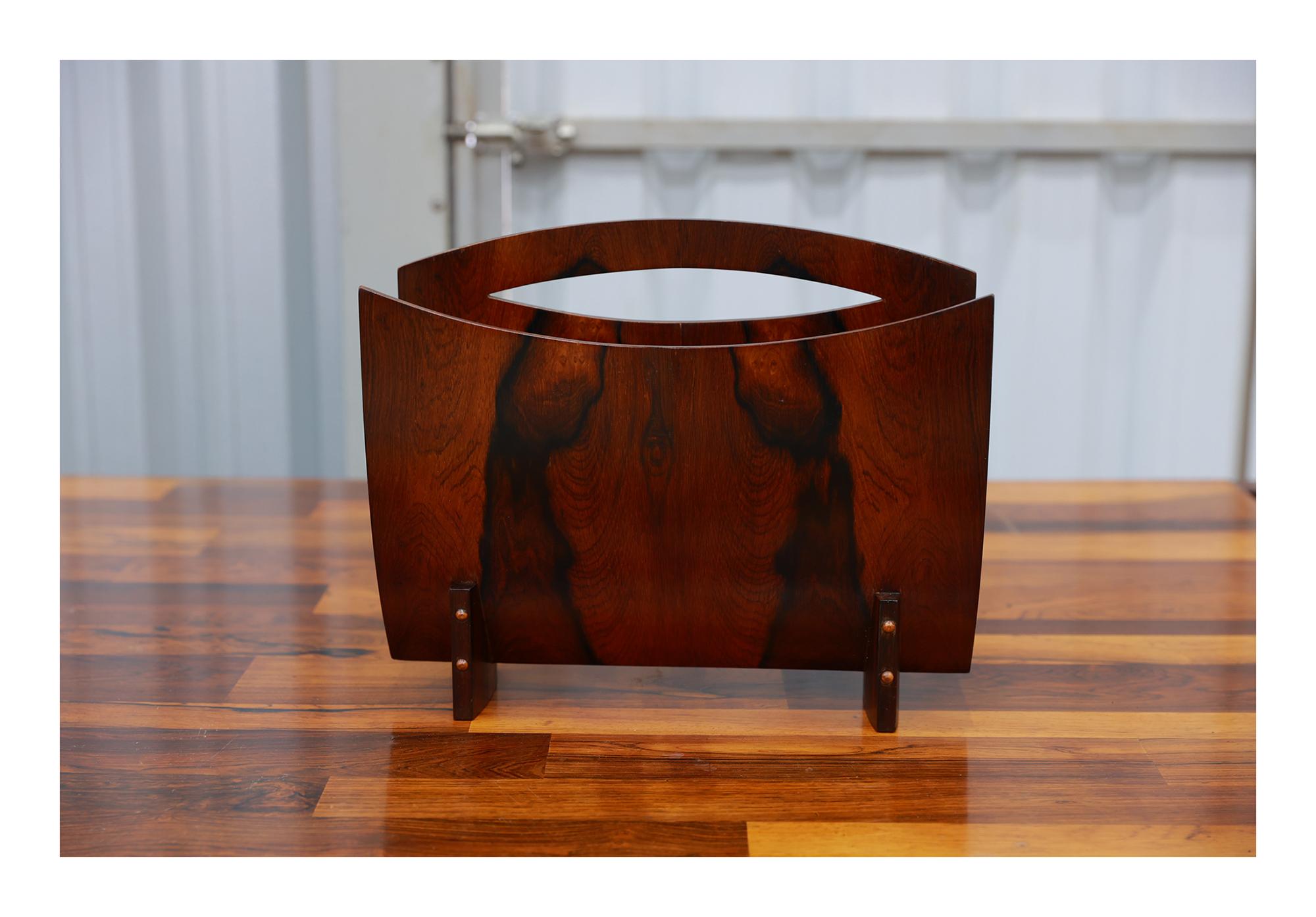 Available today, this Brazilian Modern Magazine Rack in Hardwood made in the sixties is nothing less than spectacular.

The magazine rack is made with Brazilian Rosewood which is also known as Jacaranda. It has two curved sides and a base. One of