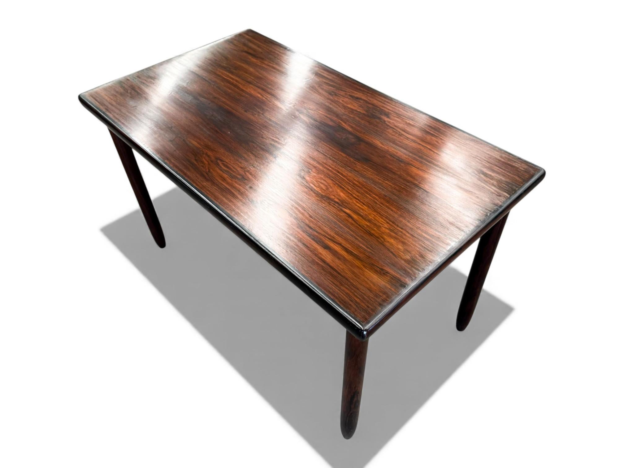 Cette table est fabriquée en bois de rose brésilien (également connu sous le nom de jacaranda). La base de la table est composée de quatre pieds arrondis et d'un plateau arrondi avec un dessus en formica blanc. Le bois a été remis à neuf, mettant en