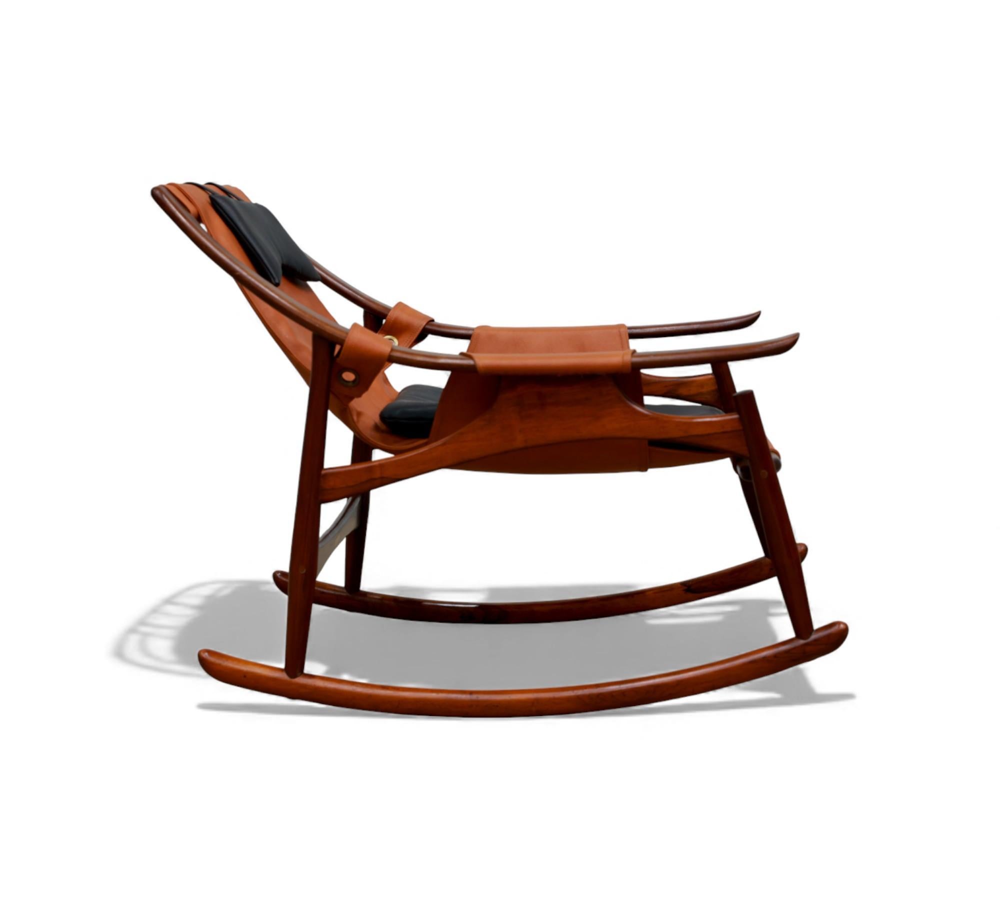 This rocking chair by Liceu de Artes is a strong example of 60s Brazilian design, combining a solid rosewood frame with a suspended natural leather seat and headrest. The chair features the workshop’s signature construction details, including curved