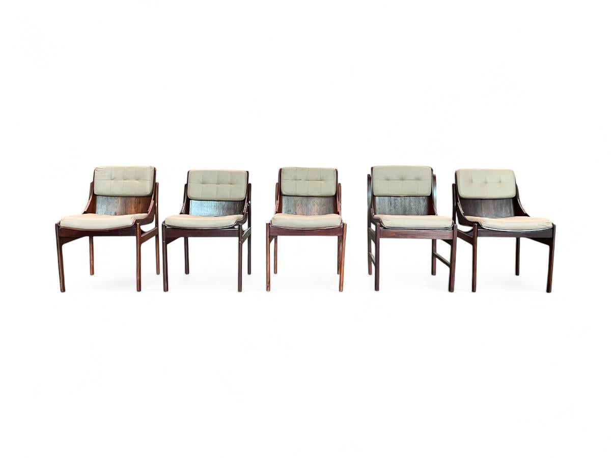 Ces chaises sont fabriquées en bois de rose brésilien avec des coussins en cuir. Le dossier et l'assise de la chaise présentent une courbure naturelle, thème que l'on retrouve dans de nombreuses pièces brésiliennes du milieu du siècle dernier. Grâce