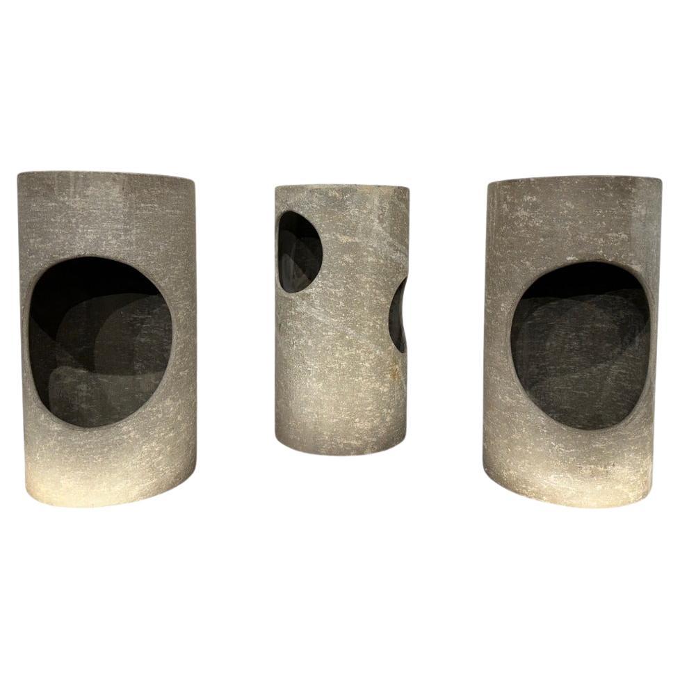 Ce charmant ensemble de trois tabourets décoratifs, fabriqué en fibre de verre dans les années 1960, présente un design cylindrique unique avec des trous sculptés de différentes formes qui créent un attrait visuel saisissant. Ces tabourets