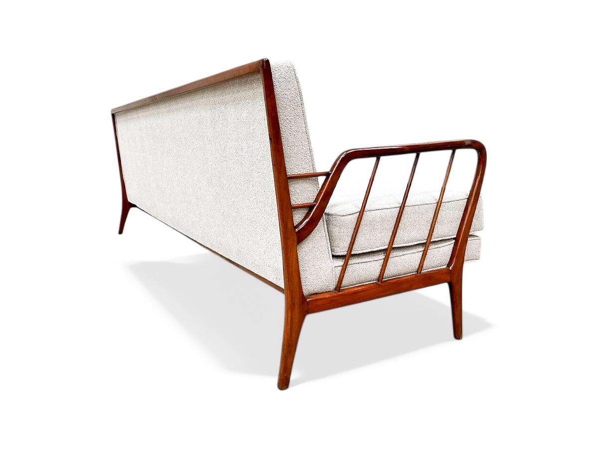 Available today, this stunning sofa embodies the essence of Brazilian mid-century design, showcasing captivating beauty through exquisite wood craftsmanship and organic shapes. The armrests, featuring tilted architectural lines, add a visually
