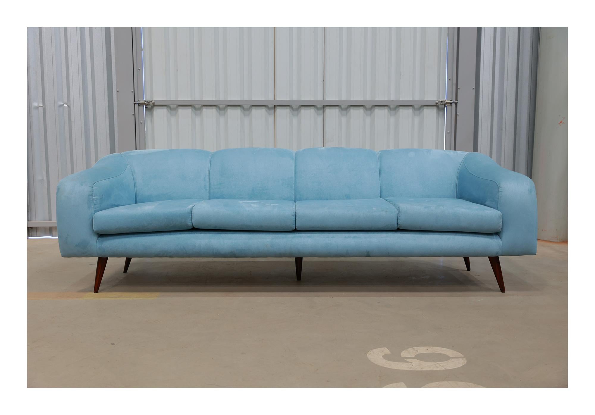 This “Curva” (curve in Portuguese) sofa was designed by Joaquim Tenreiro in the 1950s for his own company Tenreiro Moveis e Decoraçãos. It fits four people comfortably. The shell-shape-like hardwood structure is original. The legs are painted in