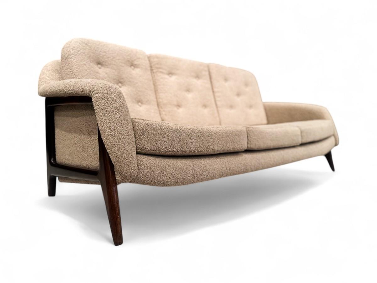 Dieses einzigartige Dreisitzer-Sofa des berühmten brasilianischen Mid-Century Modern Designers und Architekten Sergio Rodrigues (1924-2014) verfügt über einen Sockel aus brasilianischem Palisanderholz, der mit einem plüschigen, gemütlichen,