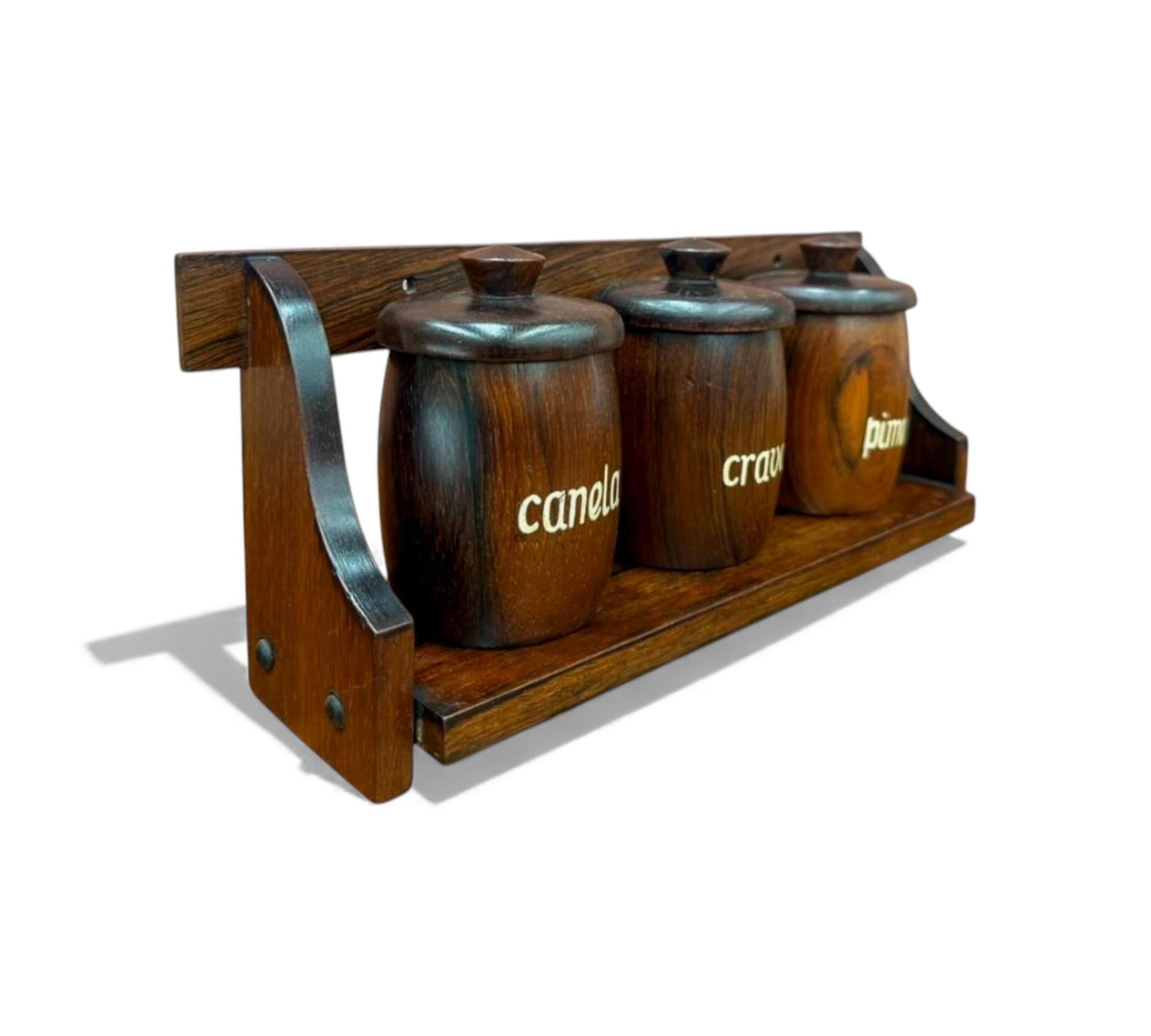 Casa Finland - Brésil, vers 1960 - Ravissante collection d'étagères à épices en bois de rose massif. Cet ensemble comprend un support mural et trois récipients à épices, tous conservant l'étiquette originale de Casa Finland.

Bio du designer :
Cette