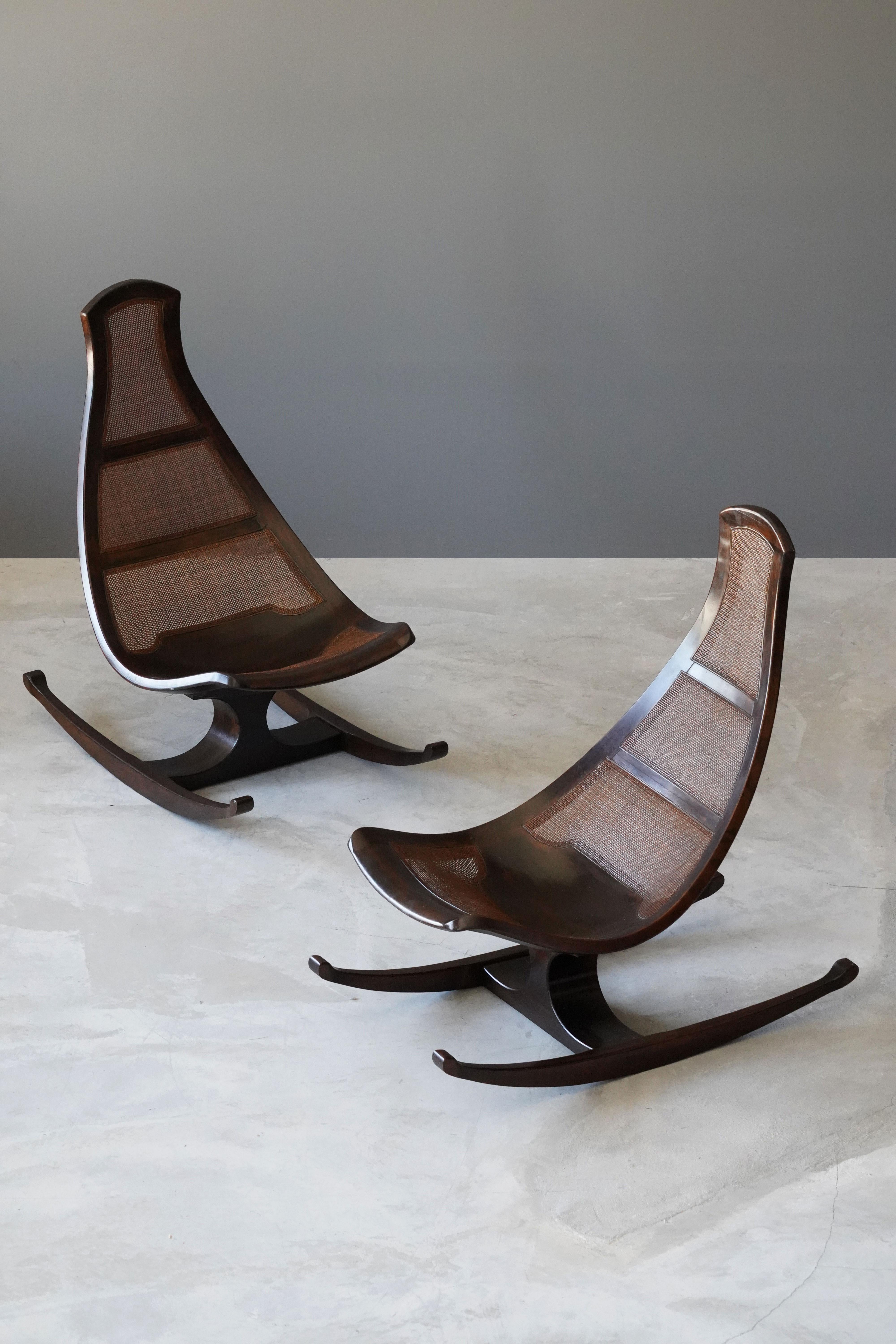 A highly modern and organic rocking lounge chair by an unknown modernist designer. Finely carved mahogany is paired with cane panels. Produced circa 1970s.

Stems from a private collection in Chicago, originally acquired at Marshall Fields,