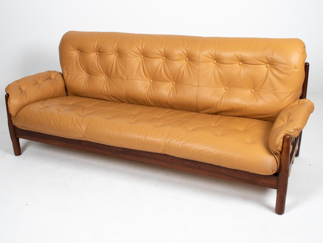 Generous proportions and luxurious finishes set this fabulous Brazilian Modernist sofa apart from the rest. The frame is crafted from gorgeous solid rosewood, with interesting sculptural chamfering at the legs. The tufted cushions are finished in