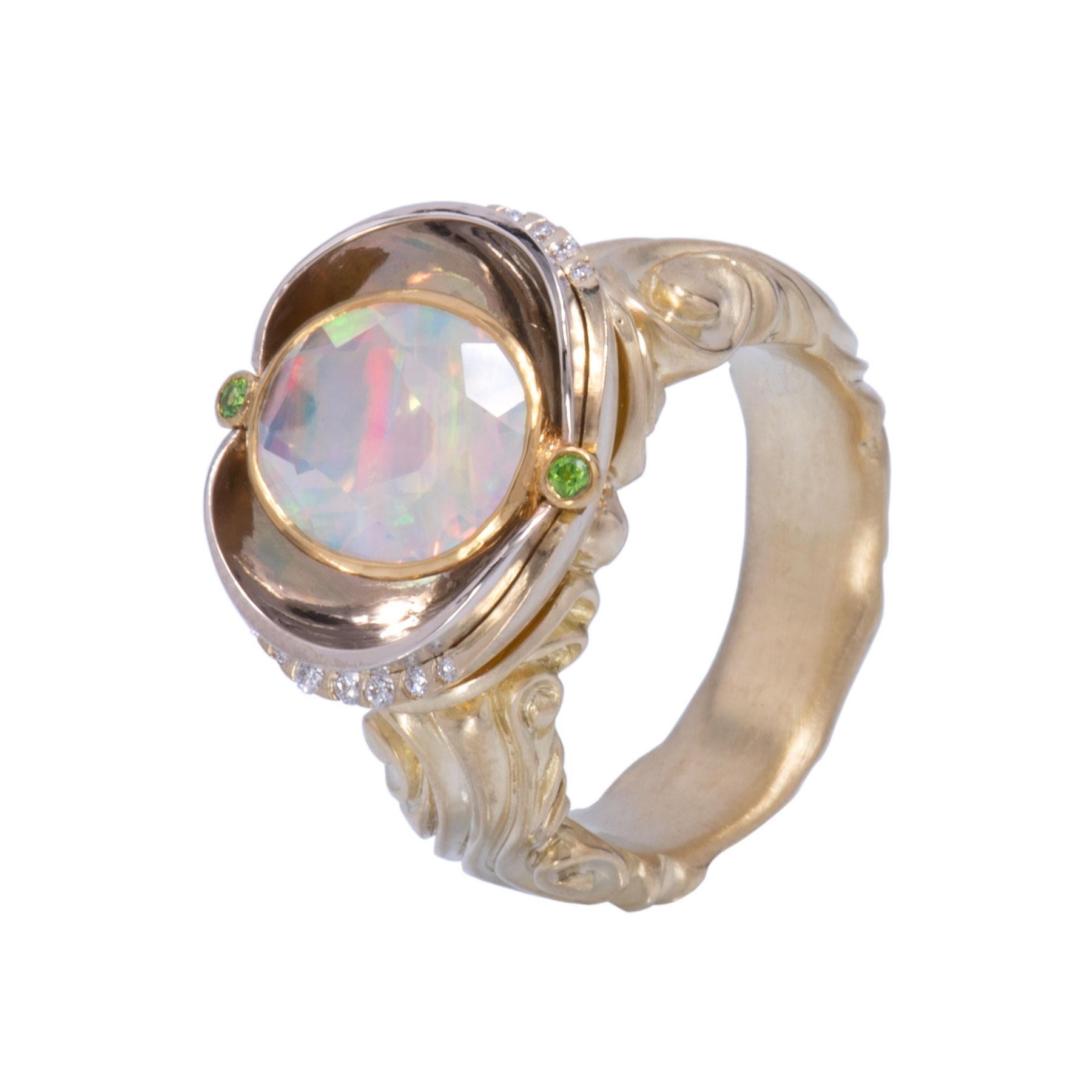 A Brazilian Opal 2.63cts is open set in 18 karat gold and mounted within an oval bowl of 18 karat white gold. Cross set ovals create a reflecting bowl that mirror the stone above. At the ends of the Brazilian Opal, 2 demantoid garnets .04tcw in