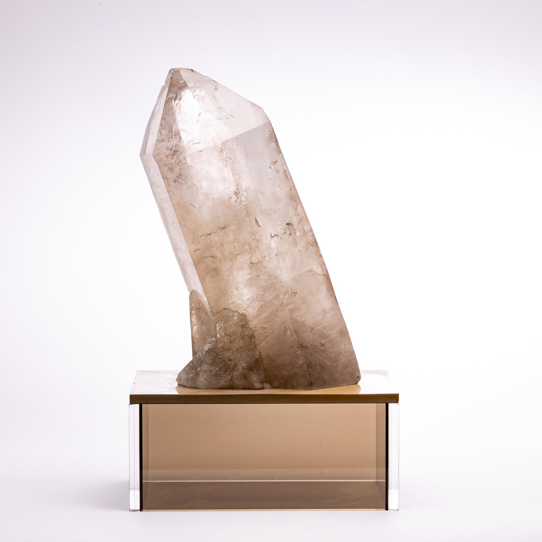 Natural large quartz point from Brazil mounted on a custom metal and smoky acrylic stand.