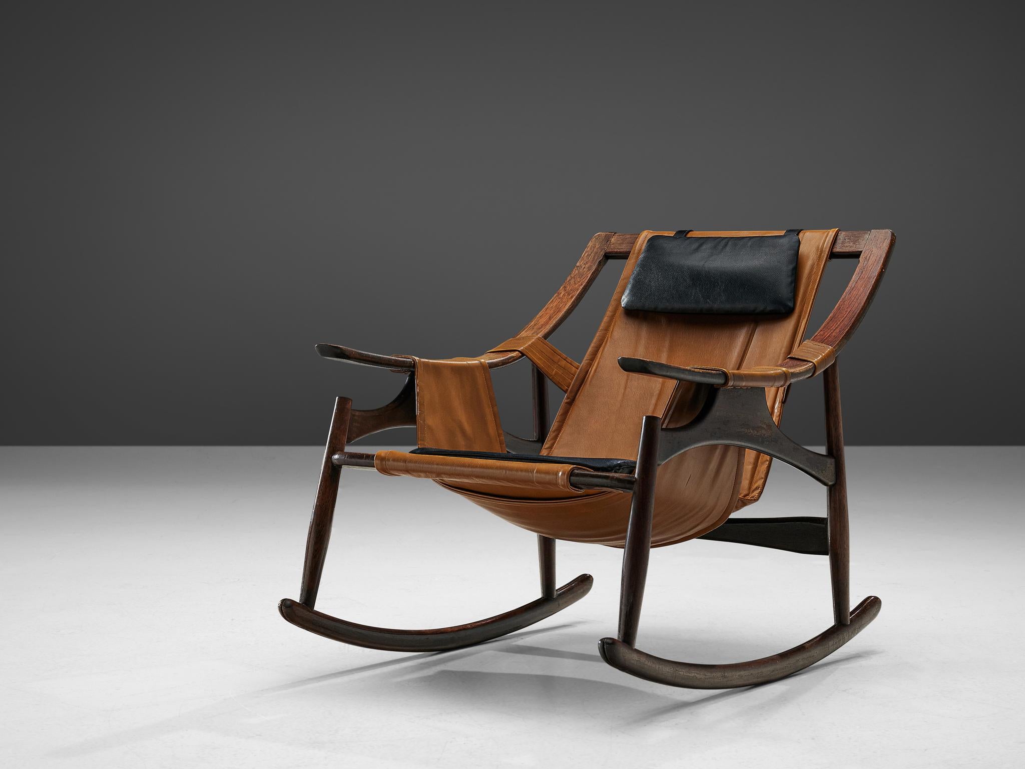 Liceu de Artes e Oficios, rocking chair, Brazilian walnut, leather, Brazil, 1960s. 

This lounge chair of Brazilian origin has an open structure based on round forms and curved lines. Both sides are joined by swinging arches which serve to hold the
