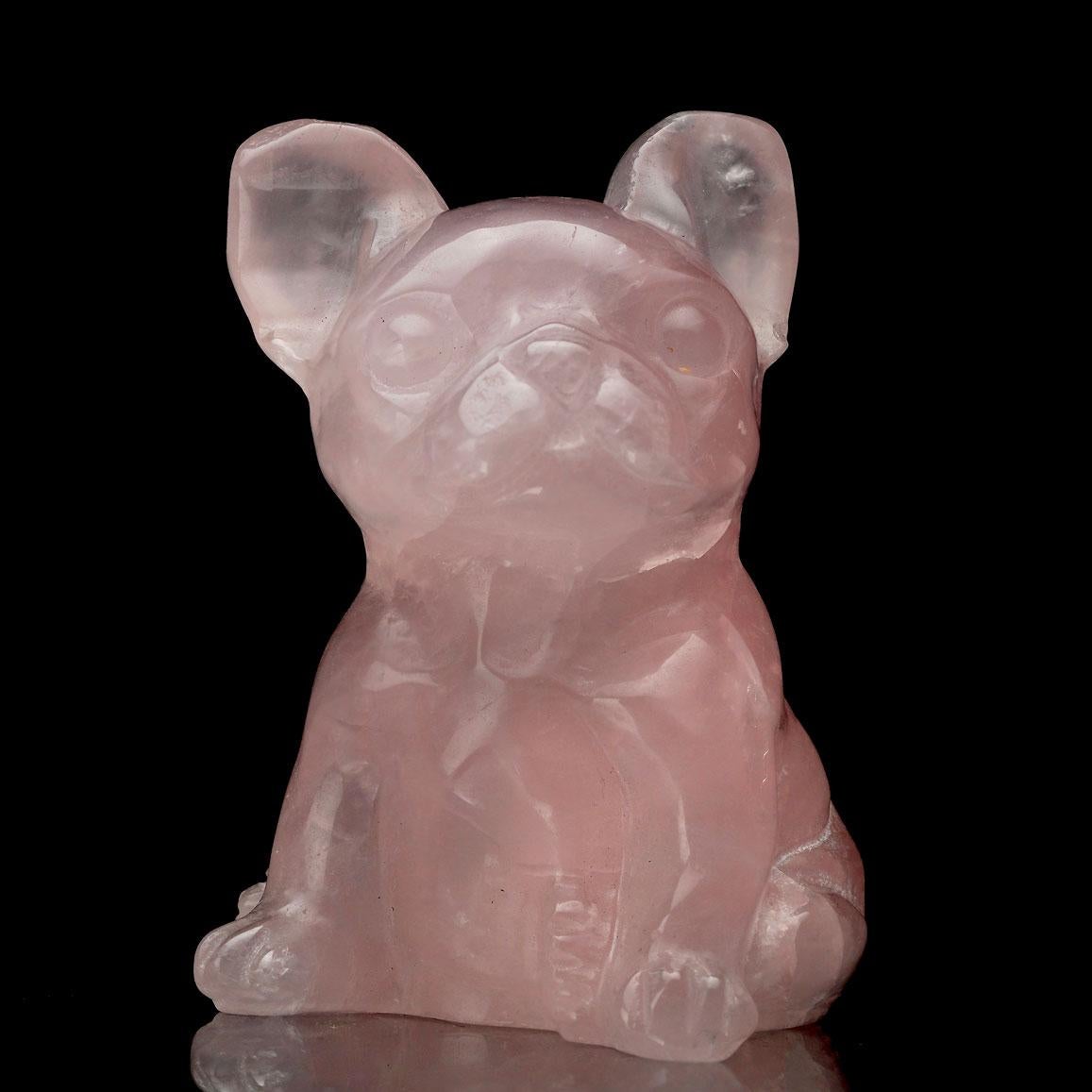 This charming Rose Quartz carving, shaped into an adorable dog figure, is a delightful combination of artistry and natural beauty. The soft pink hue of the Rose Quartz exudes a soothing, loving energy, while the intricate carving captures the