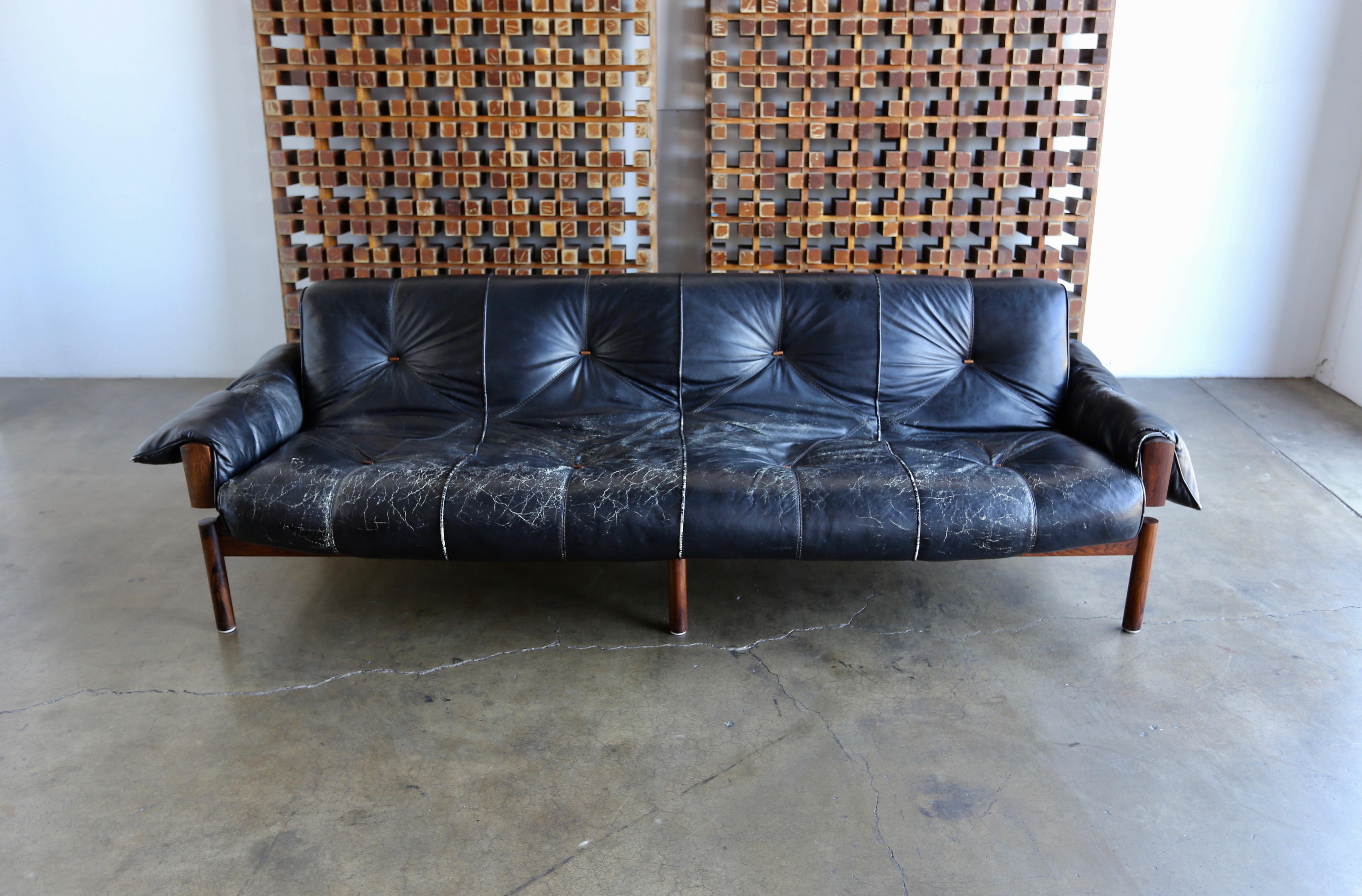 Brazilian rosewood and leather sofa by Percival Lafer, Brazil, circa 1970. Highly figured rosewood frame with beautifully distressed original black leather.

The listed measurements are to the outside of each arm cushion.