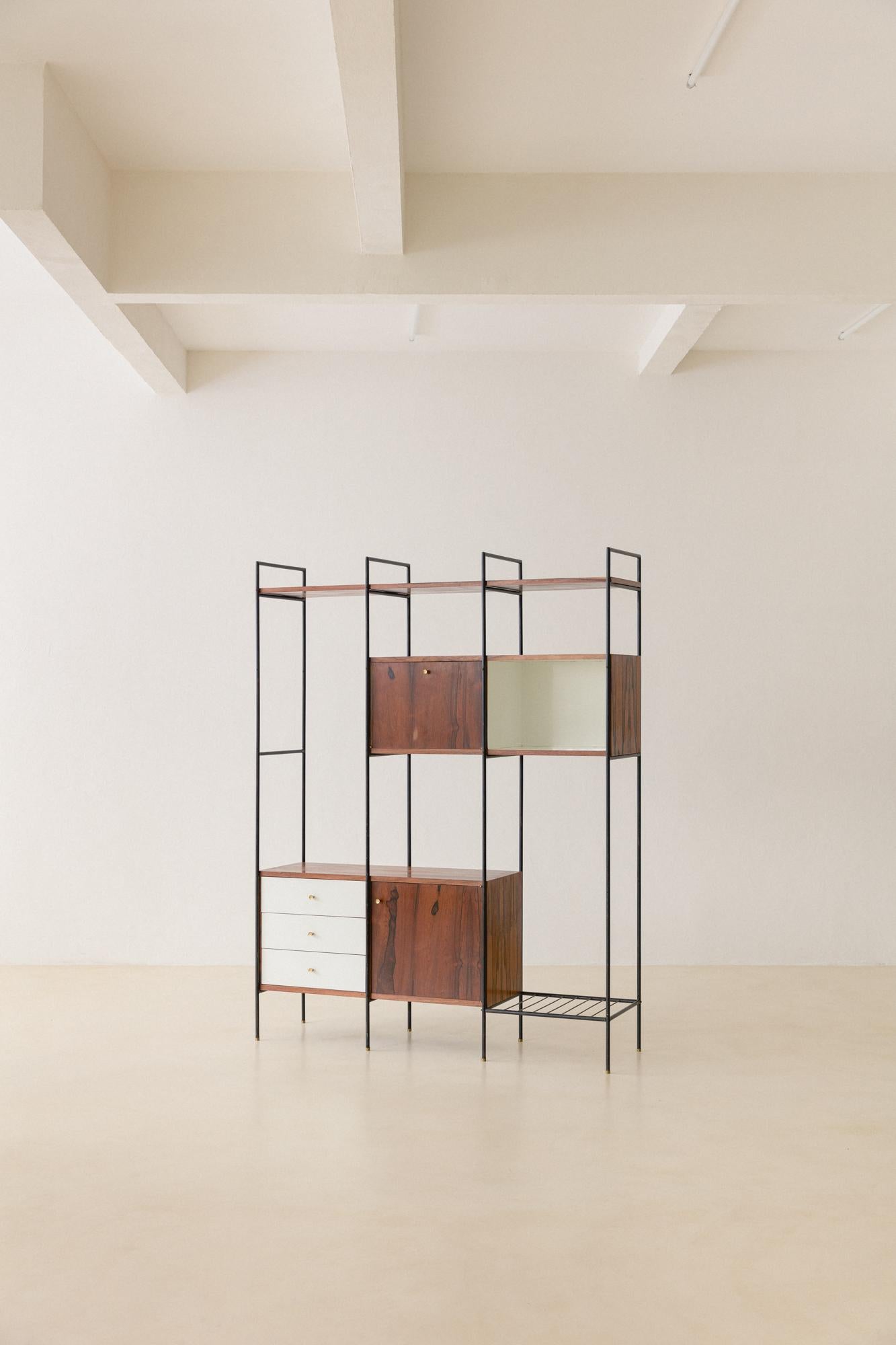 This bookshelf was designed in the 1950s by Geraldo de Barros (1923-1998) and produced by Unilabor. He designed and projected furniture based on his constructive references related to concrete Art. 

Its structure is made of iron, with storage