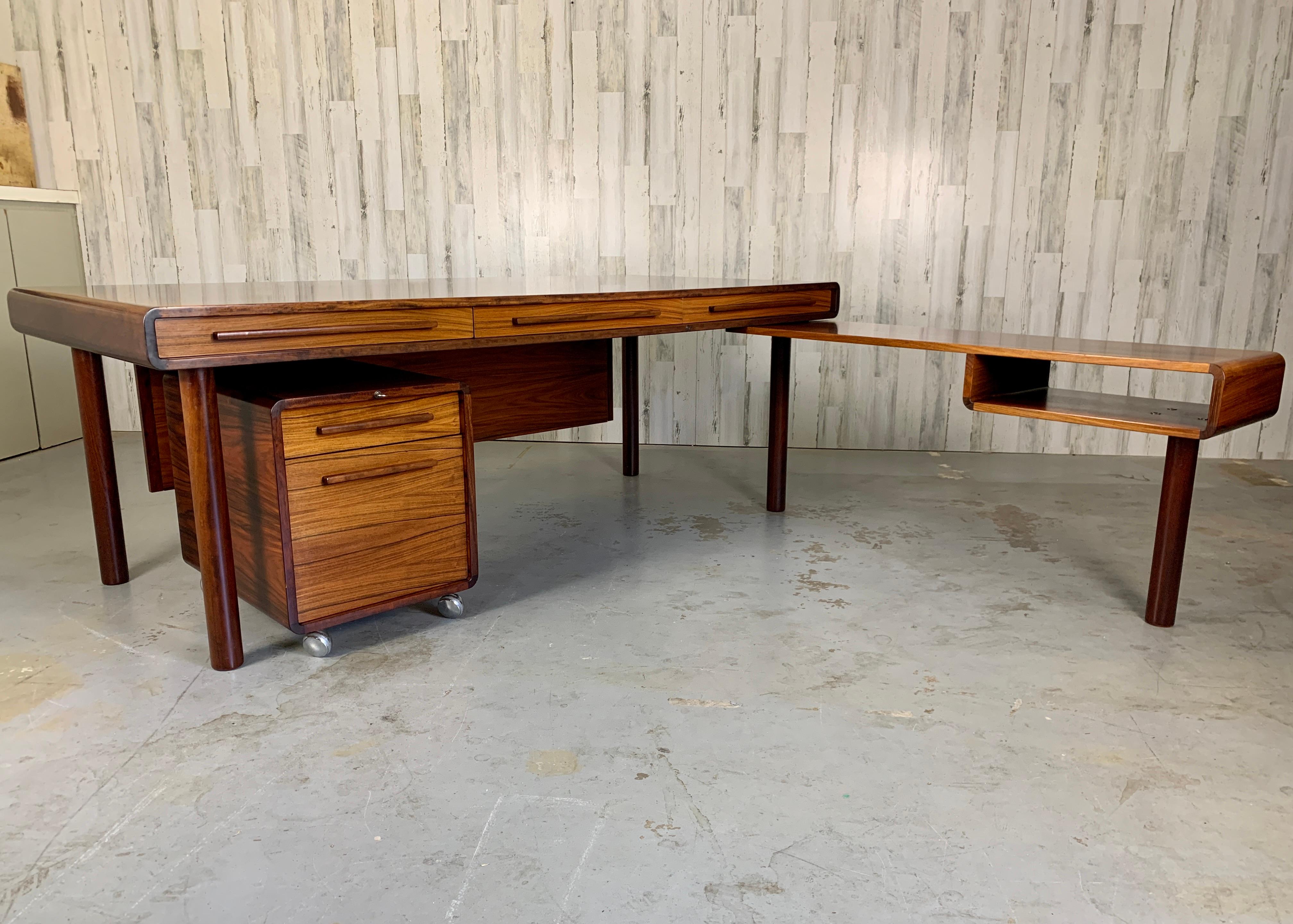 Brazilian Rosewood Danish Modern large desk with side credenza that can be mounted on either side of the desk and Island file drawer cabinet on casters. Also a removable modesty panel. Designer: Svend Dyrlund for Dyrlund
Side Extension desk: 48W x