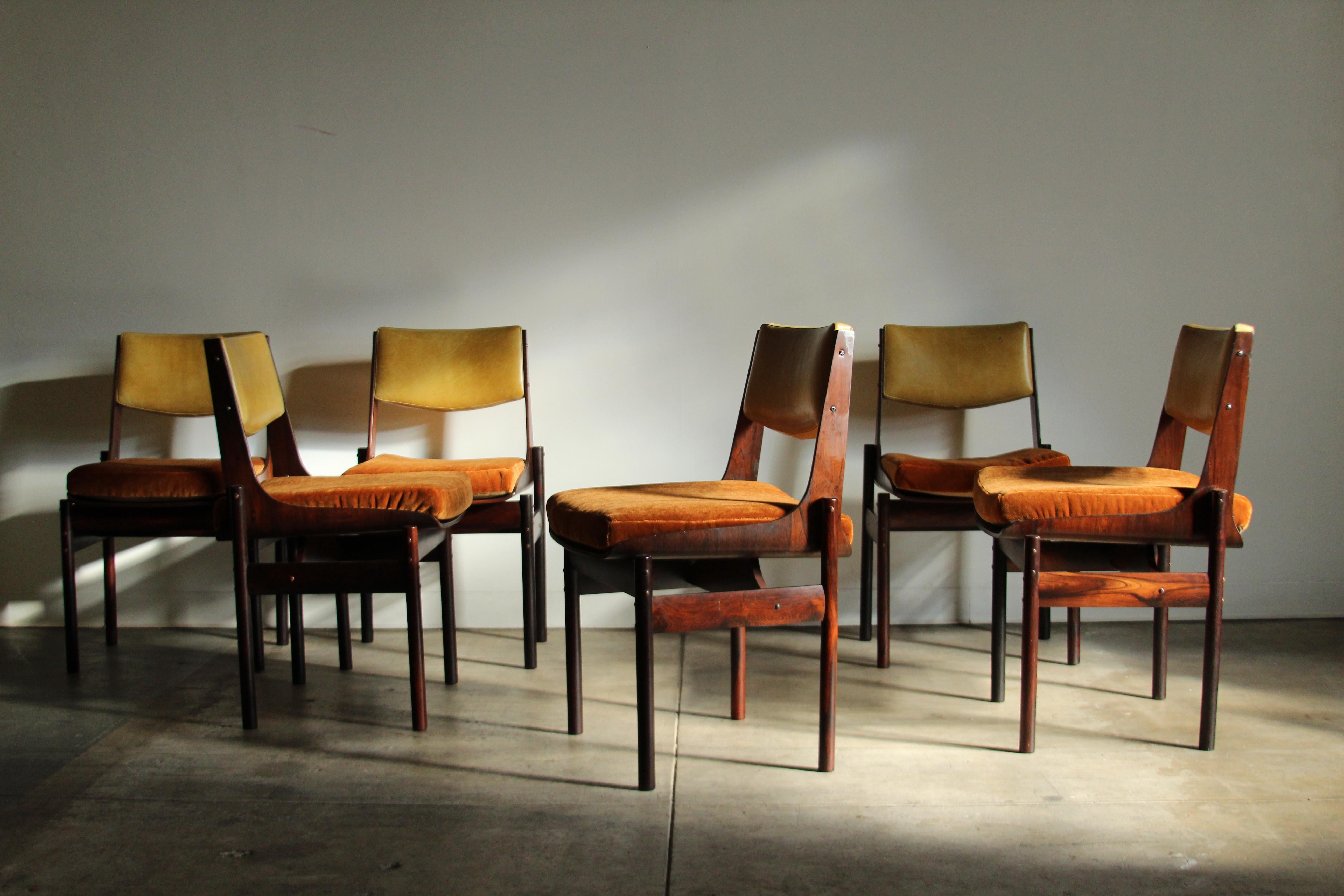 A spectacular set of 6 Brazilian rosewood dining chairs attributed to the renowned Brazilian designer, Jorge Zalszupin. The chairs consist of stunning rosewood frames with original citrine leather back cushions and brand new burnt orange mohair seat