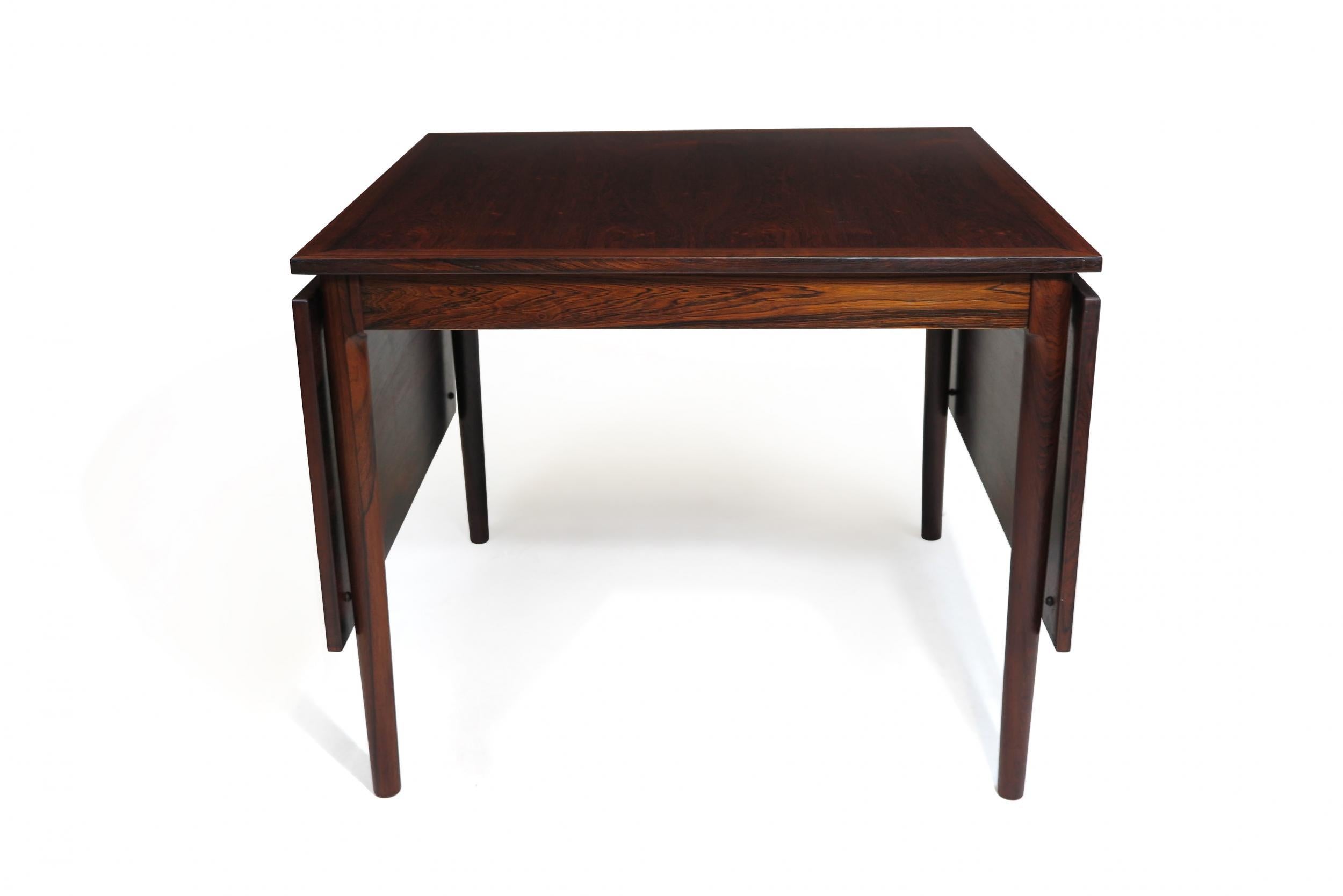 Danish Brazilian Rosewood drop-leaf dining table crafted of Brazilian rosewood with a consistent color-rich dark grain on the table and leaves; raised on tapered legs. The table can be modified to numerous configurations to suit different spaces.