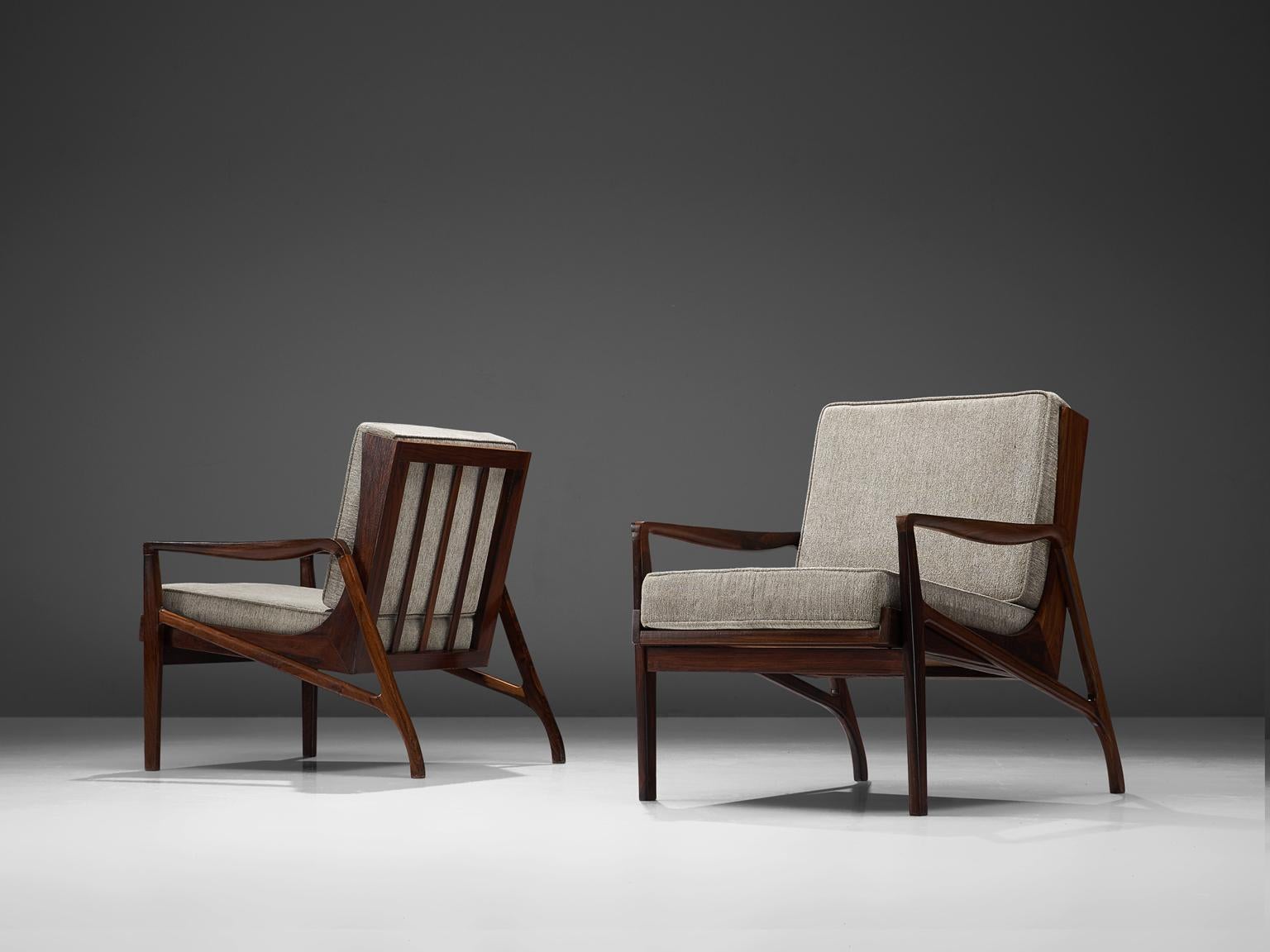 Liceu de Artes e Oficios, lounge chairs in grey fabric and rosewood, Sao Paulo, Brazil, 1960s.

These sculptural Brazilian lounge chairs are made of solid dark stained wooden construction and feature a slatted back. The frame is delicate and