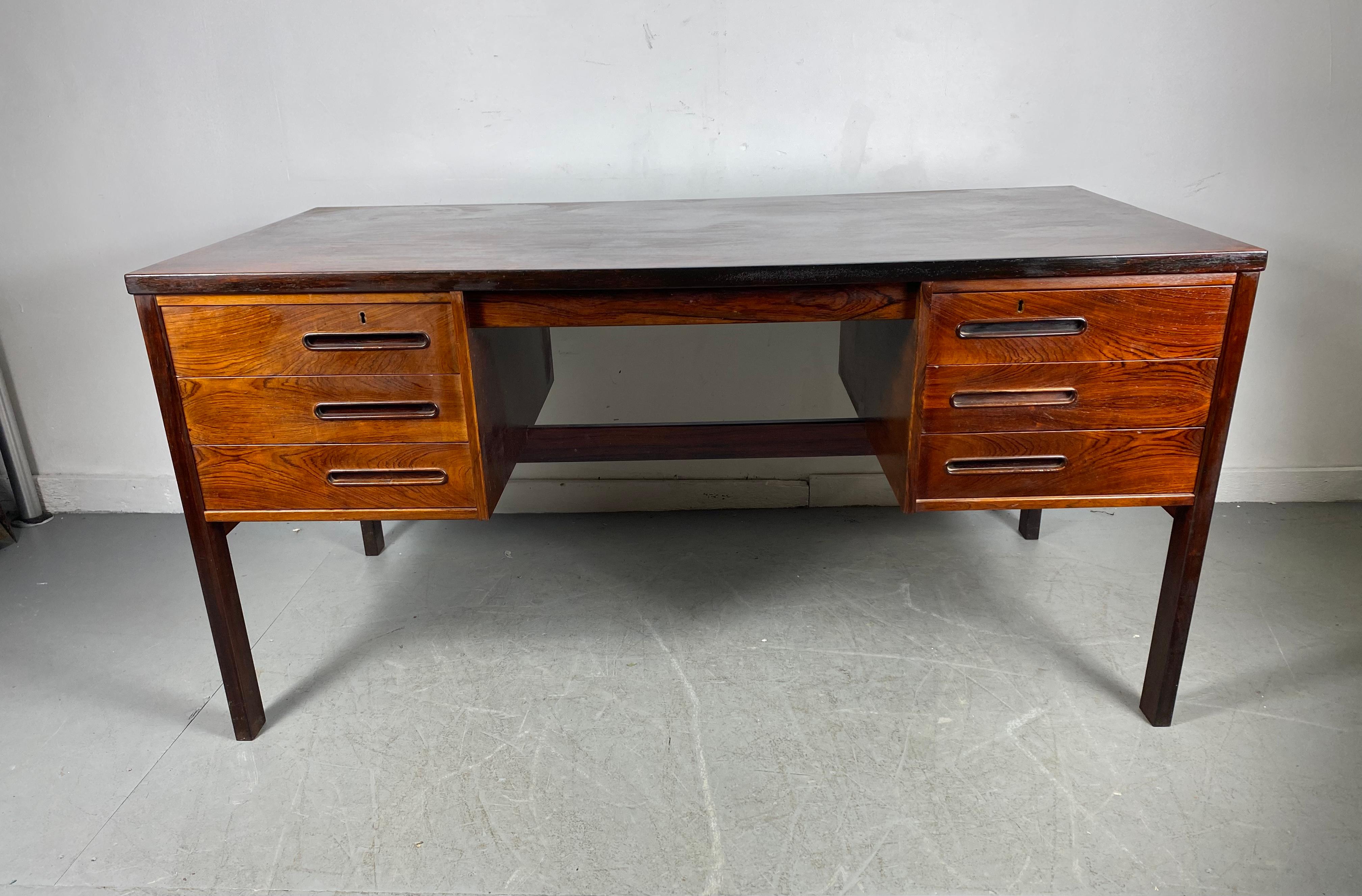 Richly grained Brazilian rosewood desk ,,made in Denmark attributed to Arne Vodder, Featuring 6 drawers,, two top locking.. dovetail joinery,, backside bookcase / cubbies.. Superior quality and construction..Hand delivery avail to New York City or