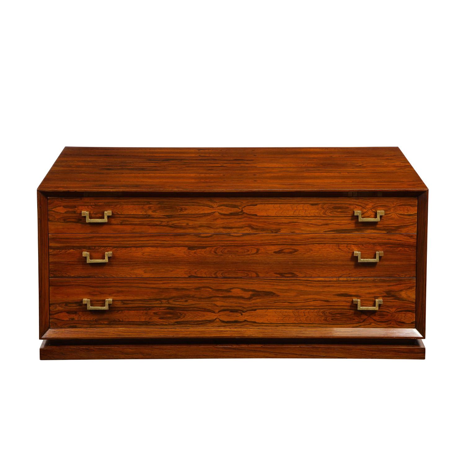 Low chest of drawers in beautifully figured Brazilian rosewood with stylized brass pulls and handles on sides, custom design, American c.1960. This piece is beautifully made.