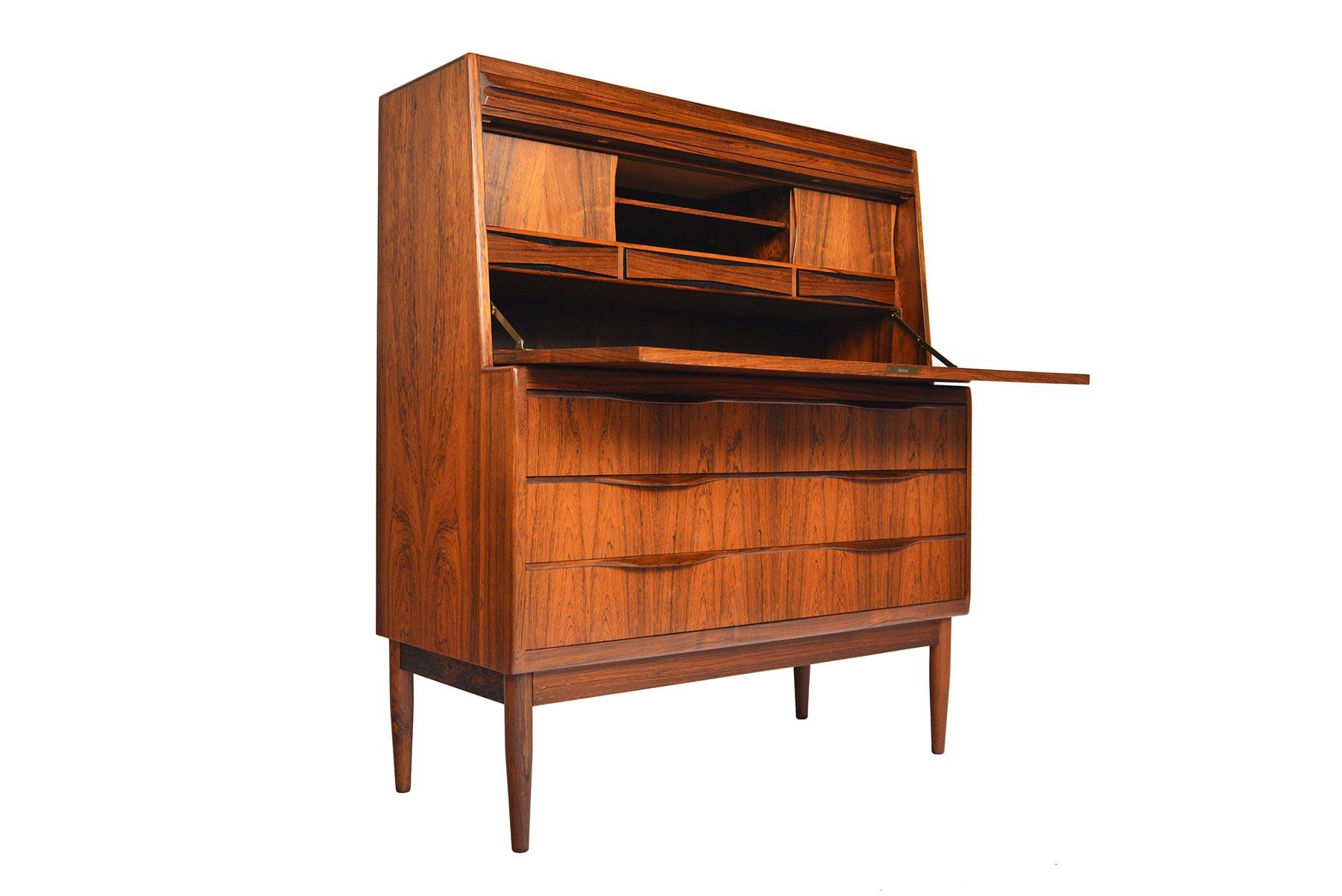 Designed by Erling Torvits for Klim Møbelfabrik in the 1960s, this rare and incredible Danish modern secretary desk is crafted from Brazilian rosewood. Top desk surface folds down to reveal three bow tie drawers, which sit below two sliding door