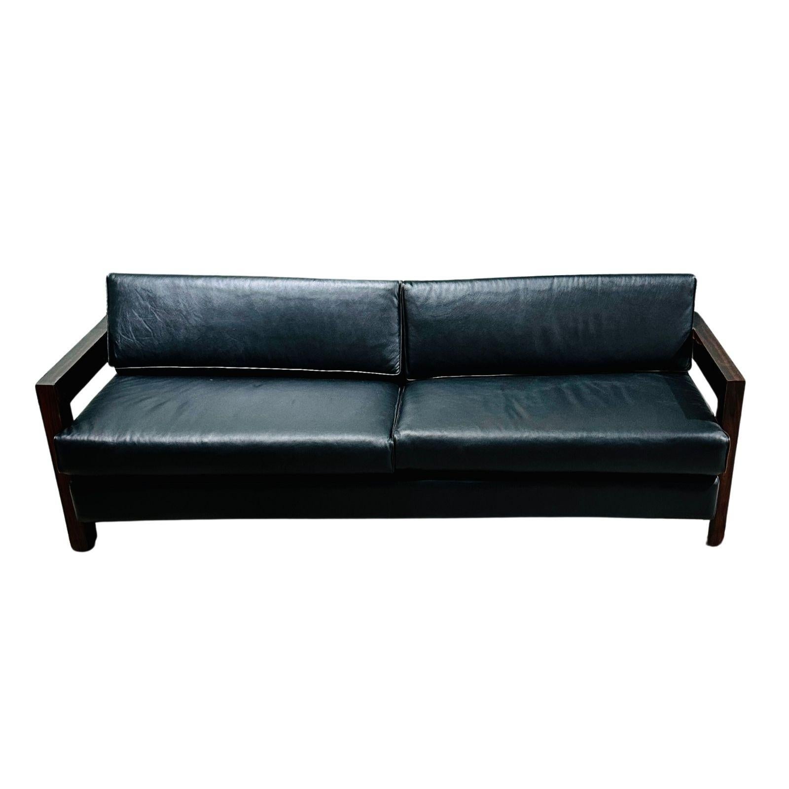 Brazilian rosewood sofa black leather, 1960. Completely restores and upholstered in black leather.
This piece is composed of solid rosewood structure, with cushions upholstered in black leather.
Sofa measures 87.5